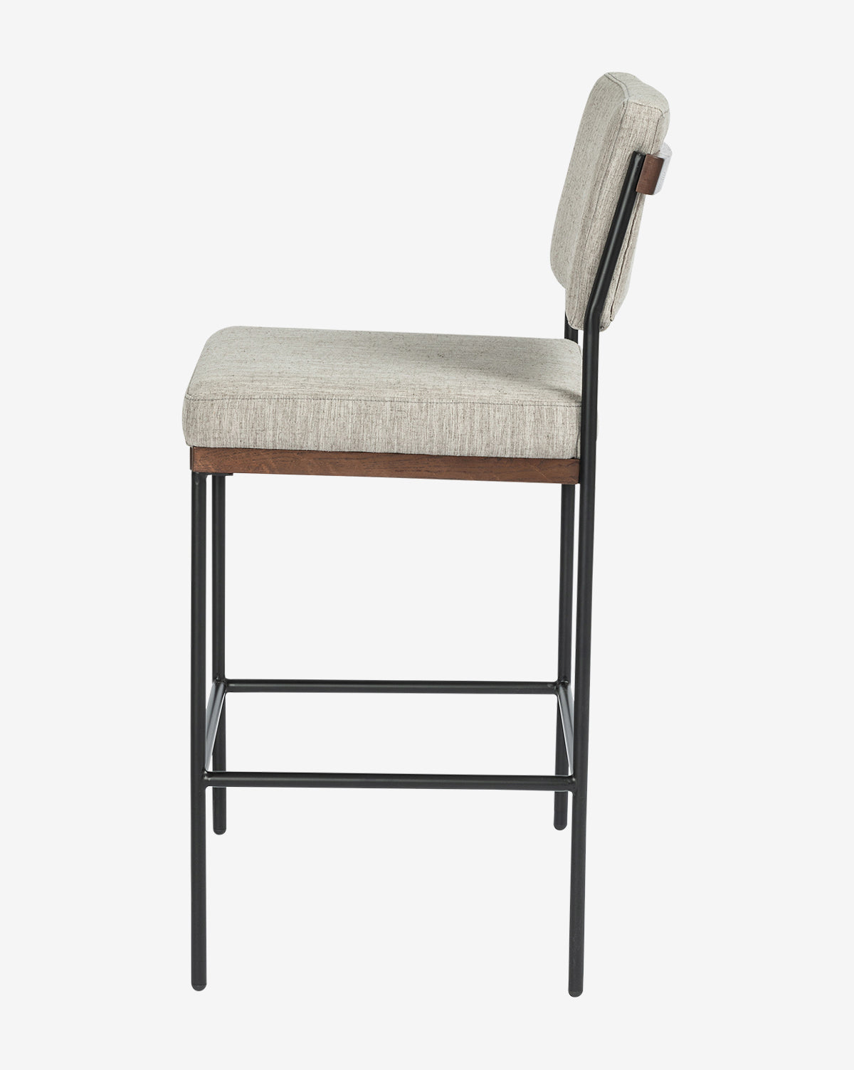 Side view of the Pascal Stool, featuring a cushioned beige seat and backrest, black iron frame with black metal legs, and a wooden accent below the seat, set against a plain white background by McGee & Co.