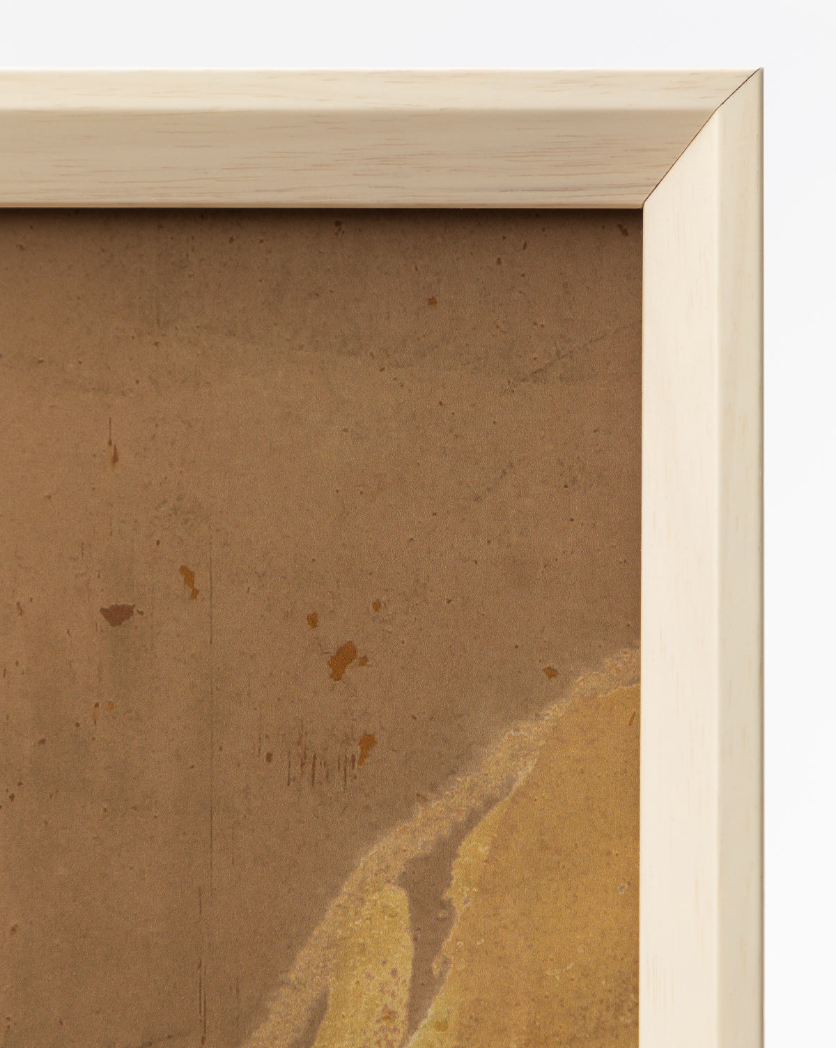 A close-up of the top right corner of a white wood frame with a light finish displays Past Petals, a brown, textured giclee print artwork featuring subtle stains and marks—an eye-catching home accent against a clean white backdrop, by McGee & Co.