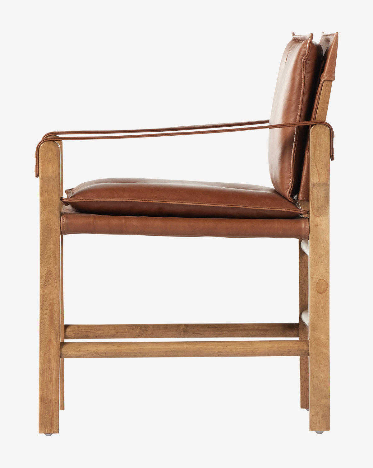Side view of the Pederson Dining Armchair featuring a honey-finished wood frame, top grain leather seat and back cushions, plus leather armrest accents. Its minimalist, contemporary design adds style to any dining space by McGee & Co.