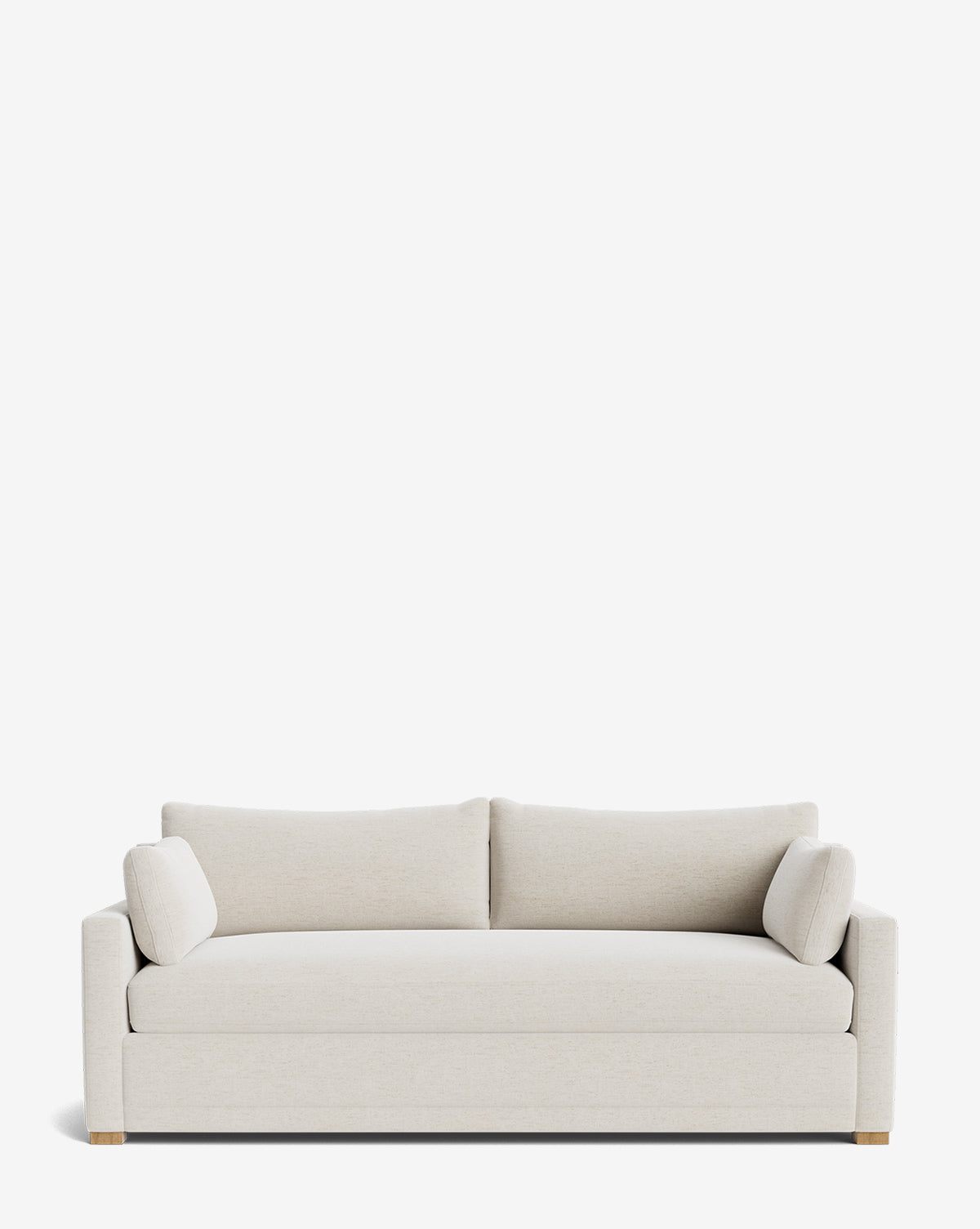 The Peterson Classic Upholstered Sofa (75 - 100) features a modern, light beige design with plush cushions, two matching cylindrical bolster pillows, straight arms, and wooden block feet against a plain white background by McGee & Co.