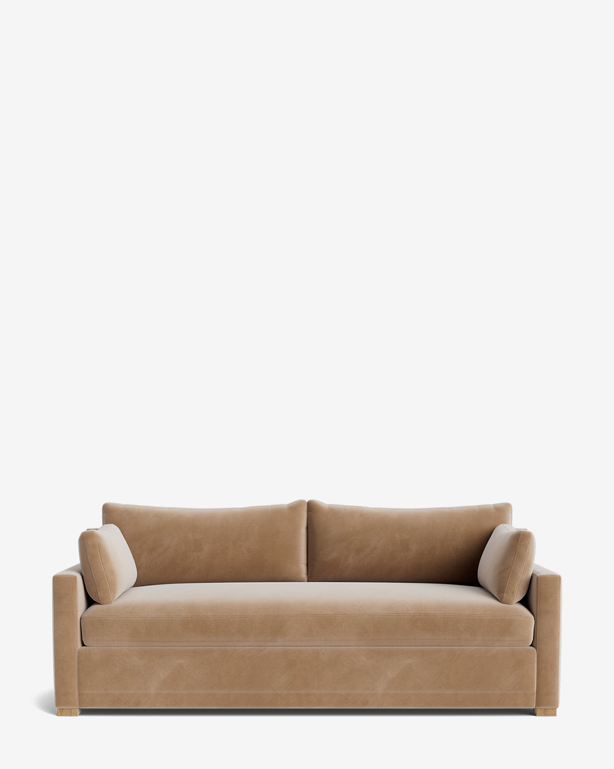 The Peterson Classic Upholstered Sofa (75 - 100) features modern, tan velvet upholstery, clean lines, square arms, two plush seat cushions, two rectangular back cushions, and cylindrical bolster pillows against a white background by McGee & Co.