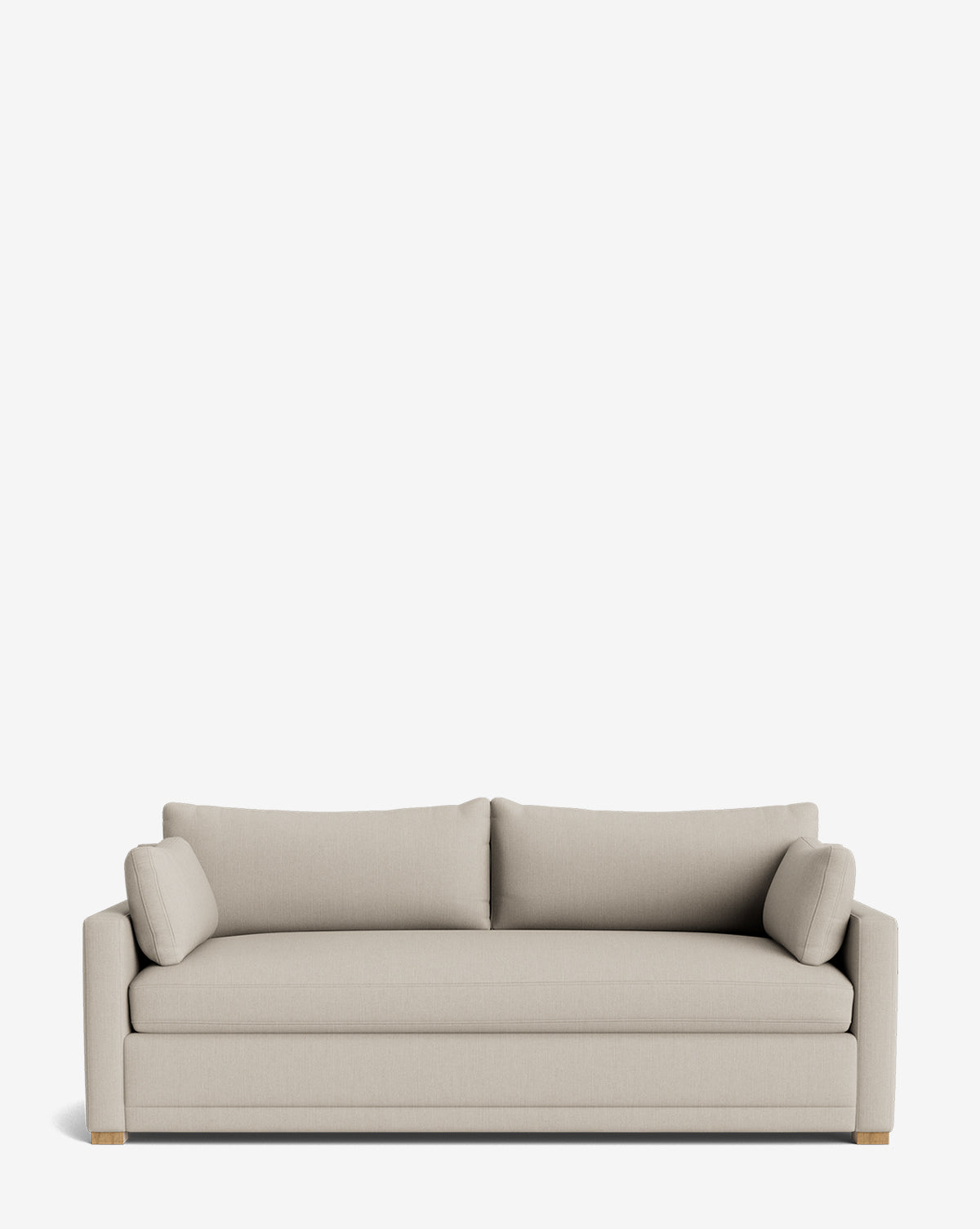 The Peterson Classic Upholstered Sofa (75 - 100) features a modern design in light beige fabric with plush cushions, two cylindrical bolster pillows, straight arms, and wooden feet, shown against a plain white background by McGee & Co.