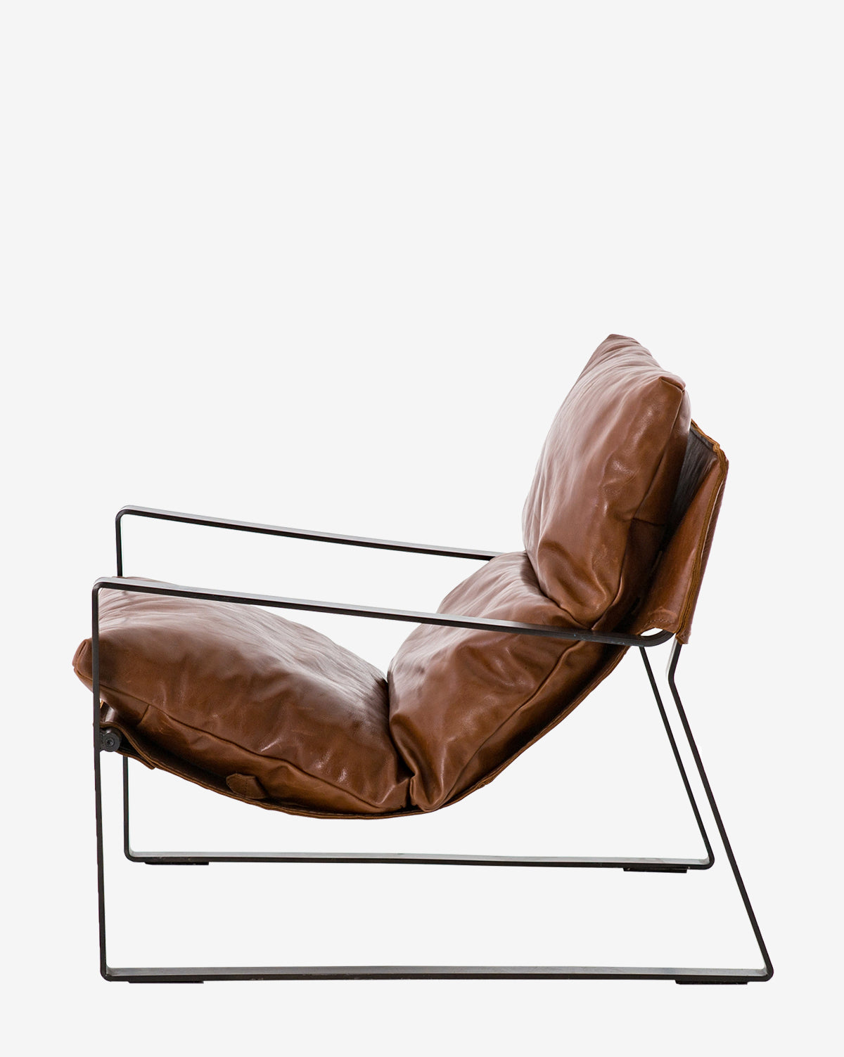Side view of the Peyton Leather Sling Chair, a modern piece with a minimalist black metal frame and spacious, plush brown leather seat and back cushions, shown against a plain white background.