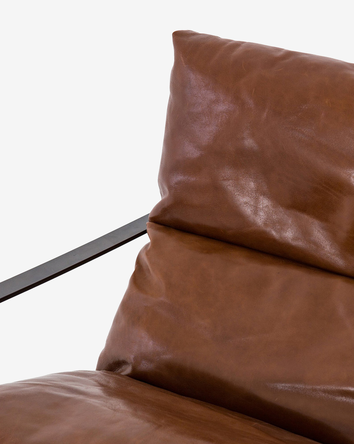 Close-up of the Peyton Leather Sling Chair, a modern design with plush brown leather cushions and slim black metal armrests, set against a white background.