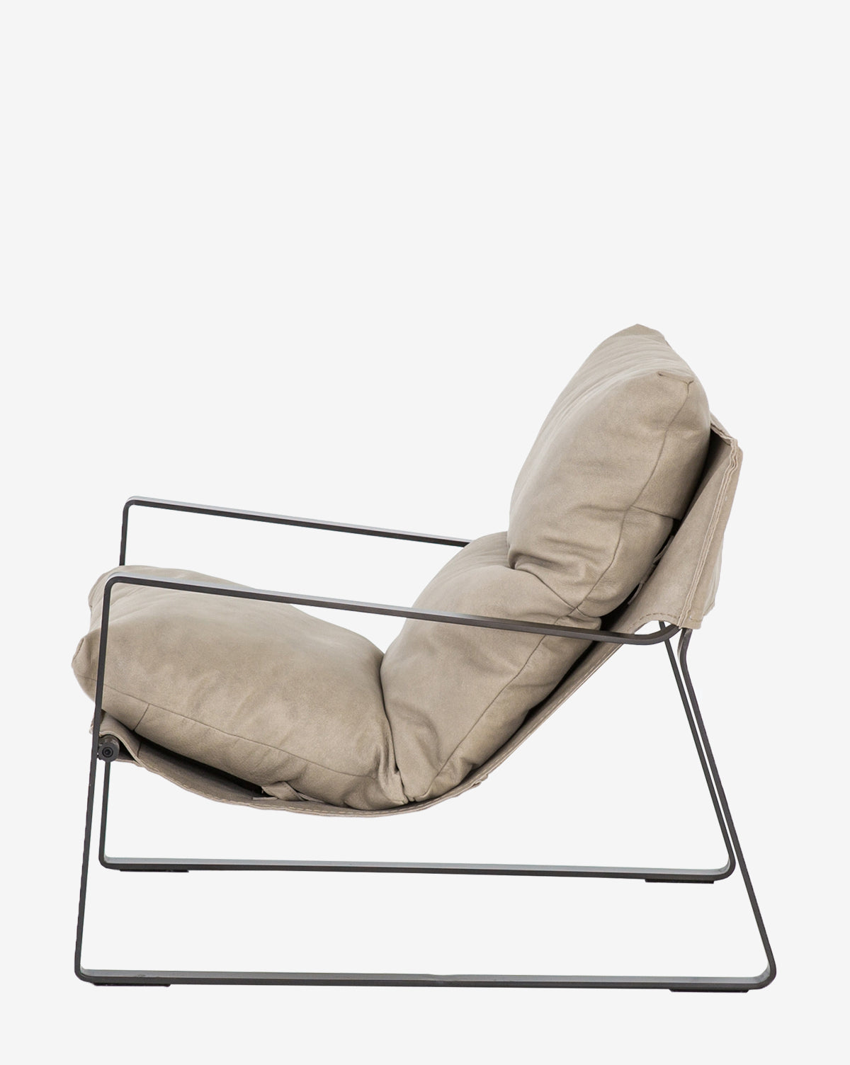 The Peyton Leather Sling Chair features a sleek black metal frame and plush light beige cushions, shown from the side against a plain white background.
