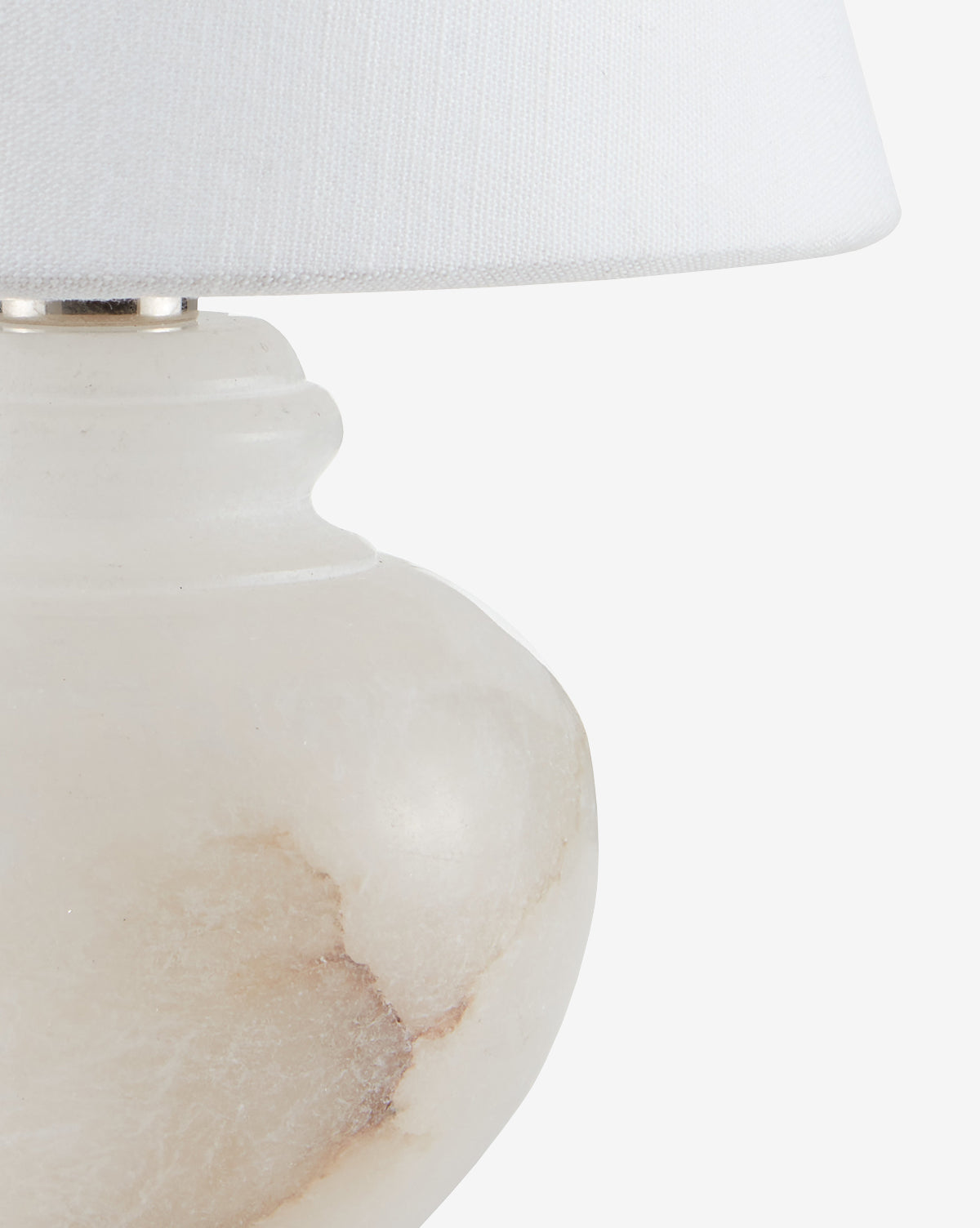 Close-up of the Piccolo Table Lamp, showcasing its white alabaster base with natural marbling and a white fabric lampshade, set against a plain white background by McGee & Co.