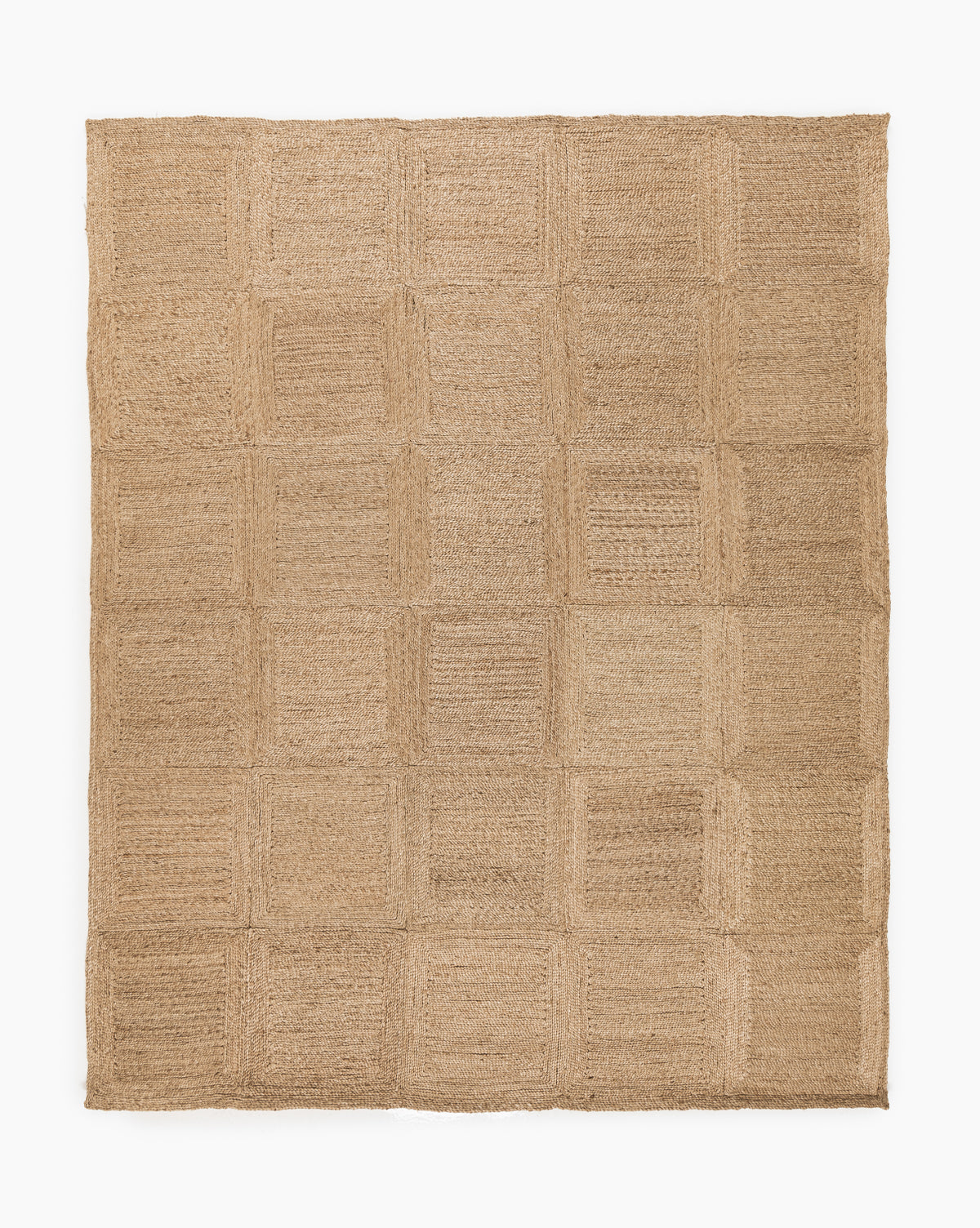 The Pieced Handwoven Jute Rug displays a subtle checkered pattern with alternating woven textures in light brown and beige tones, arranged for a rustic look against a white background, by McGee & Co.