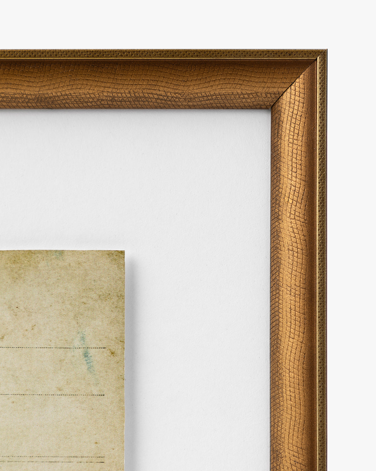 Close-up of the top right corner of a warm brown, gold-finished Post Card Address wood frame with a white mat and part of an aged, yellowed vintage note inside. The visible texture enhances this classic display, by McGee & Co.