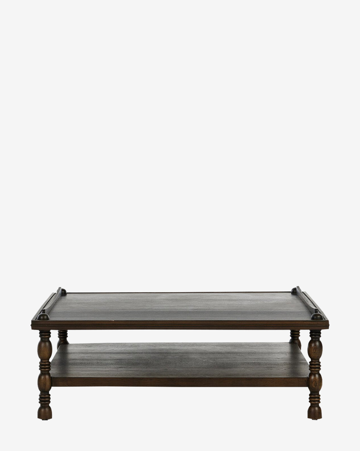 The Rhodes Coffee Table has a dark oak veneer, rectangular top, turned legs, and a lower storage shelf. This elegant two-tier table is pictured against a plain white background by McGee & Co.