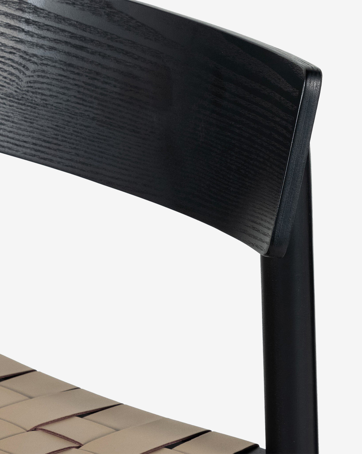 Close-up of the Robson Stool, featuring a black wooden backrest and woven leather seat. This kitchen stool showcases clean lines and a minimalist modern design, by McGee & Co.
