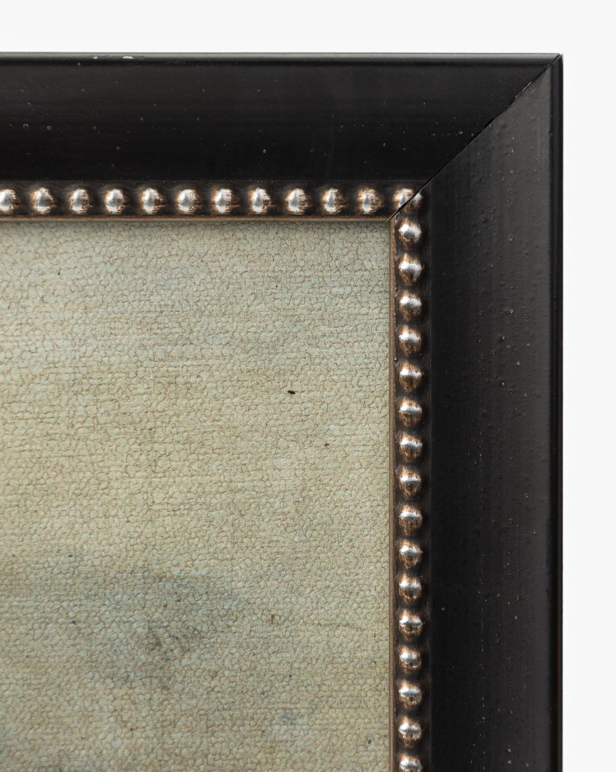 Close-up of a gallery-quality black wood frame with round metallic beads on the inside edge, encasing the textured Rough Sea Shores canvas and highlighting its coastal-inspired design, by McGee & Co.