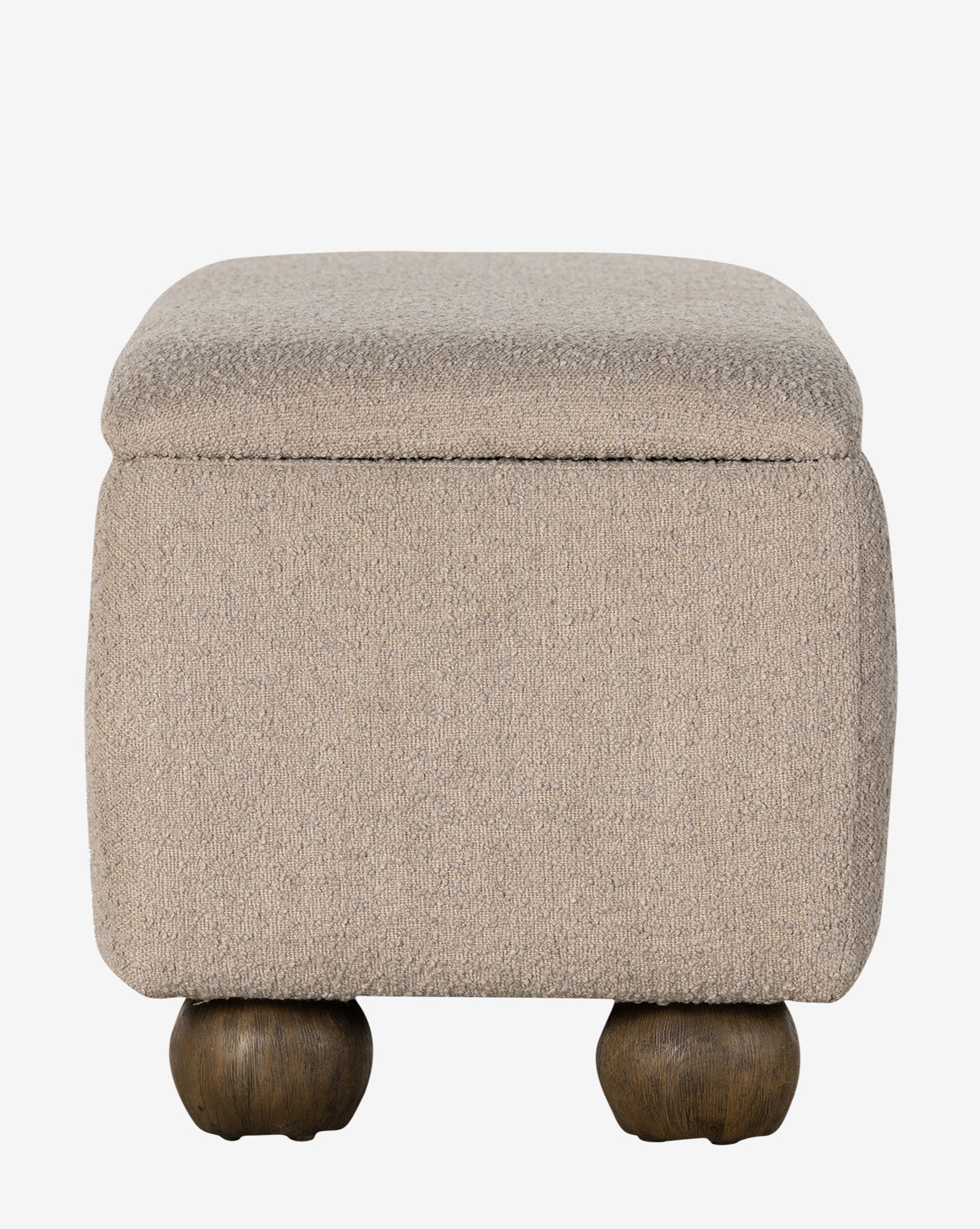 The Rowley Trunk is a square, beige upholstered ottoman with a cushioned top and four round, dark wooden legs in a modern design, shown against a plain white background by McGee & Co.