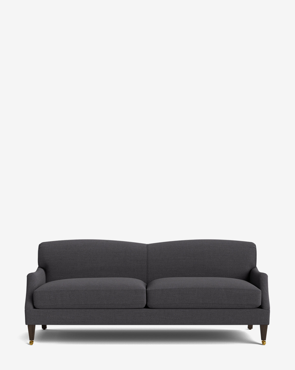 The Rowley Sofa 85 is a modern, hand-crafted dark gray sofa with two seat cushions, low arms, and short wooden legs with brass casters, displayed on a plain white background by McGee & Co.