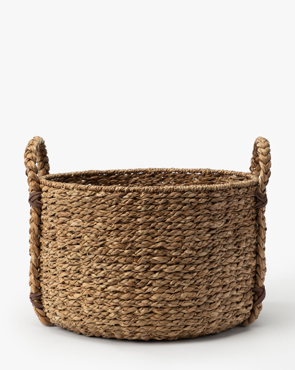 The Salter Woven Basket, crafted from natural fibers and featuring two sturdy side handles, is displayed against a plain white background by McGee & Co.