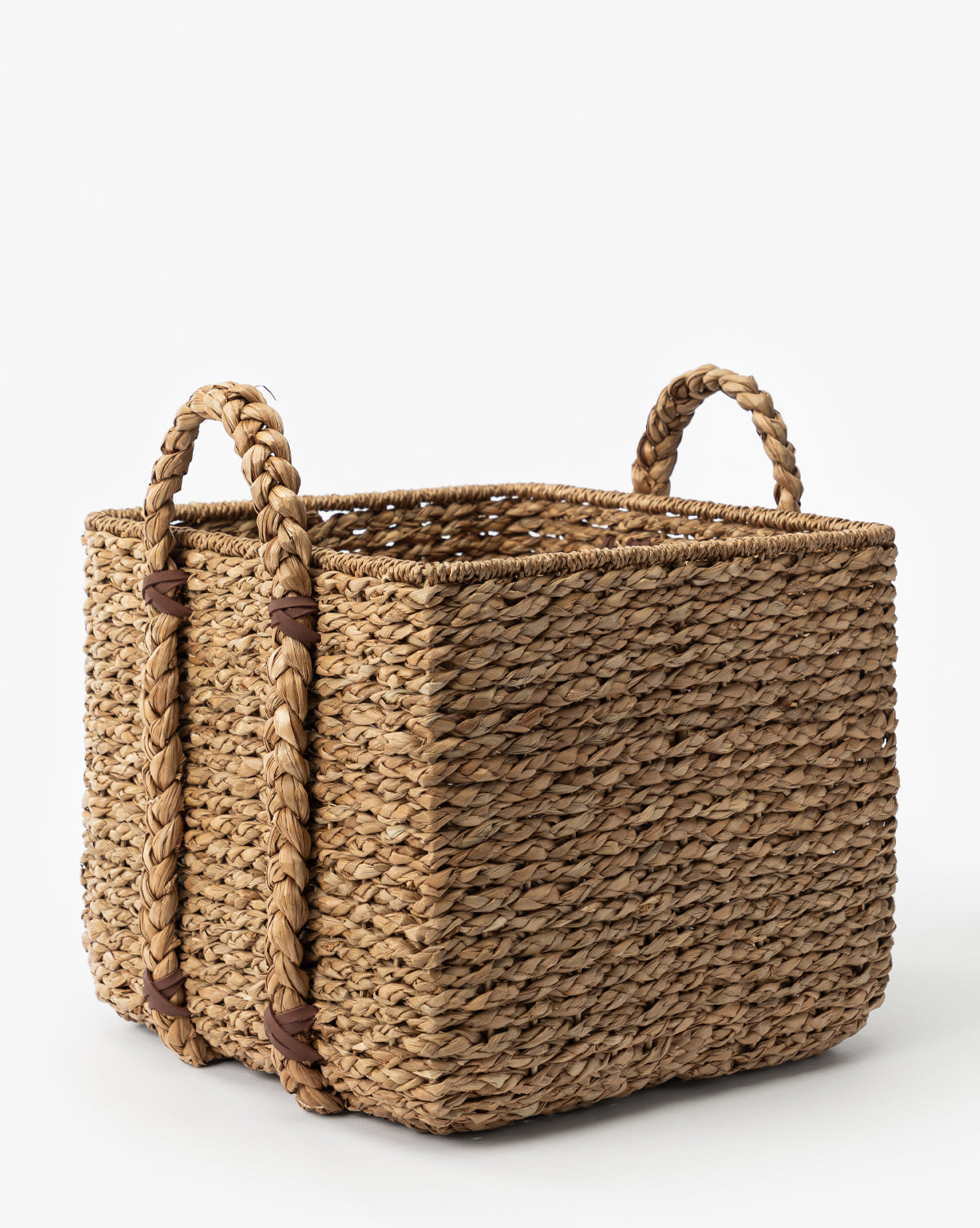The Salter Woven Square Basket, crafted from natural seagrass fibers and featuring two sturdy looped handles on each side, sits elegantly on a white background by McGee & Co.