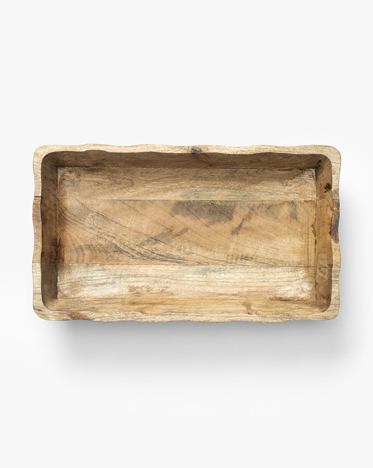 The Scalloped Wood Tray is a handcrafted rectangular tray made from mango wood, featuring uneven scalloped edges and visible natural grain, shown from above on a plain white background by McGee & Co.