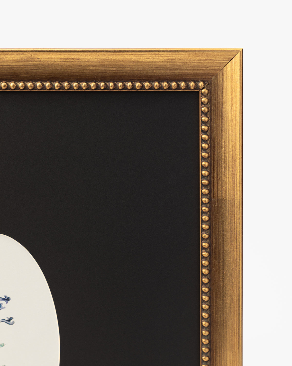 A close-up of the gold beaded frame corner showcases Single Blooms 3: a white oval botanical print with a black mat and floral detail—perfect for vintage wall art decor, by McGee & Co.