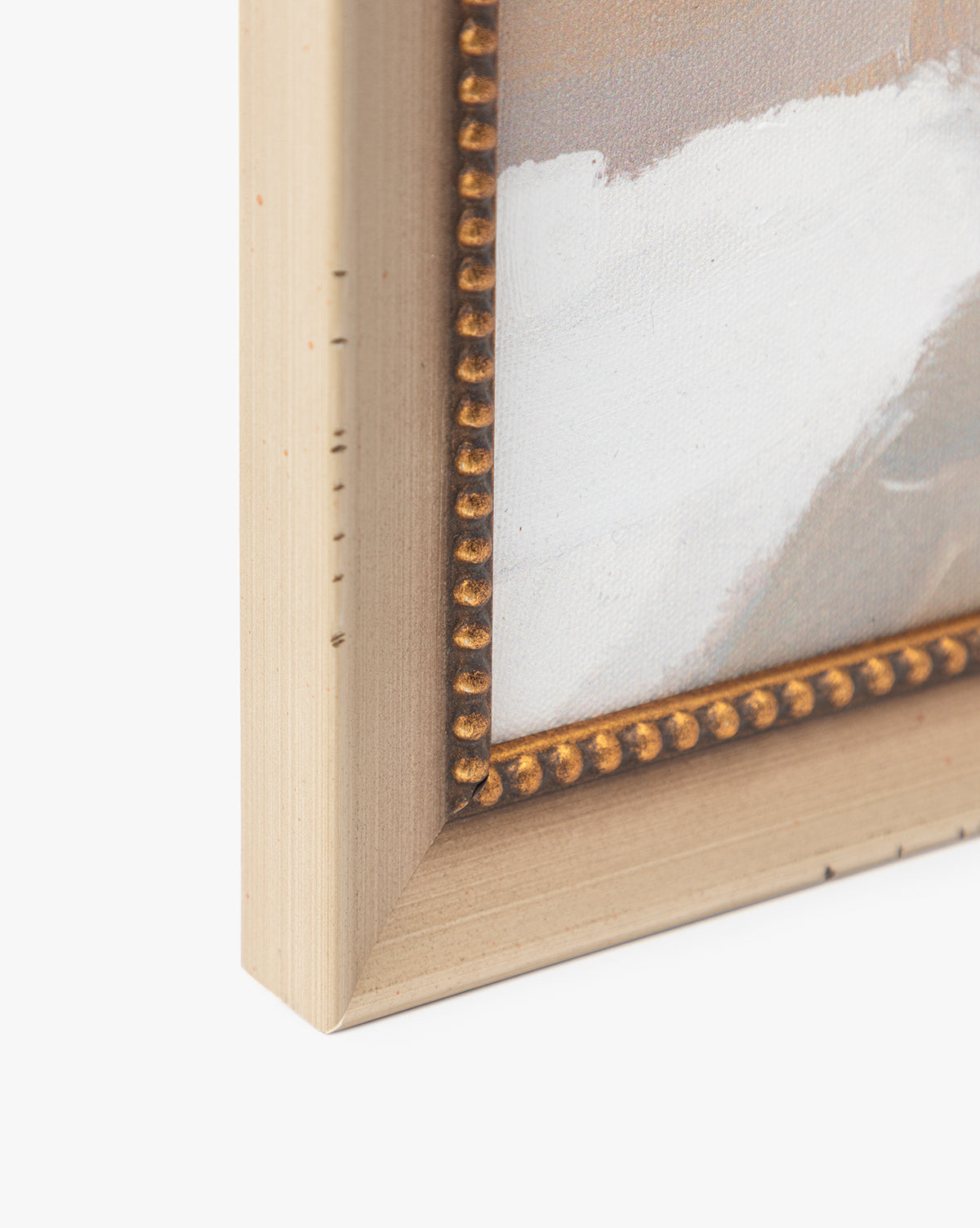 Close-up of the corner of a beige frame with a beaded edge, showing part of the Single Blossom canvas in soft white and light brown hues for a gentle, romantic look, by McGee & Co.