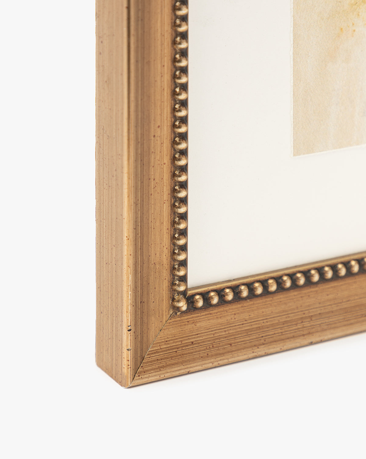 Close-up of the corner of a gold beaded picture frame with a white mat displaying part of Sky Studies 6 artwork.