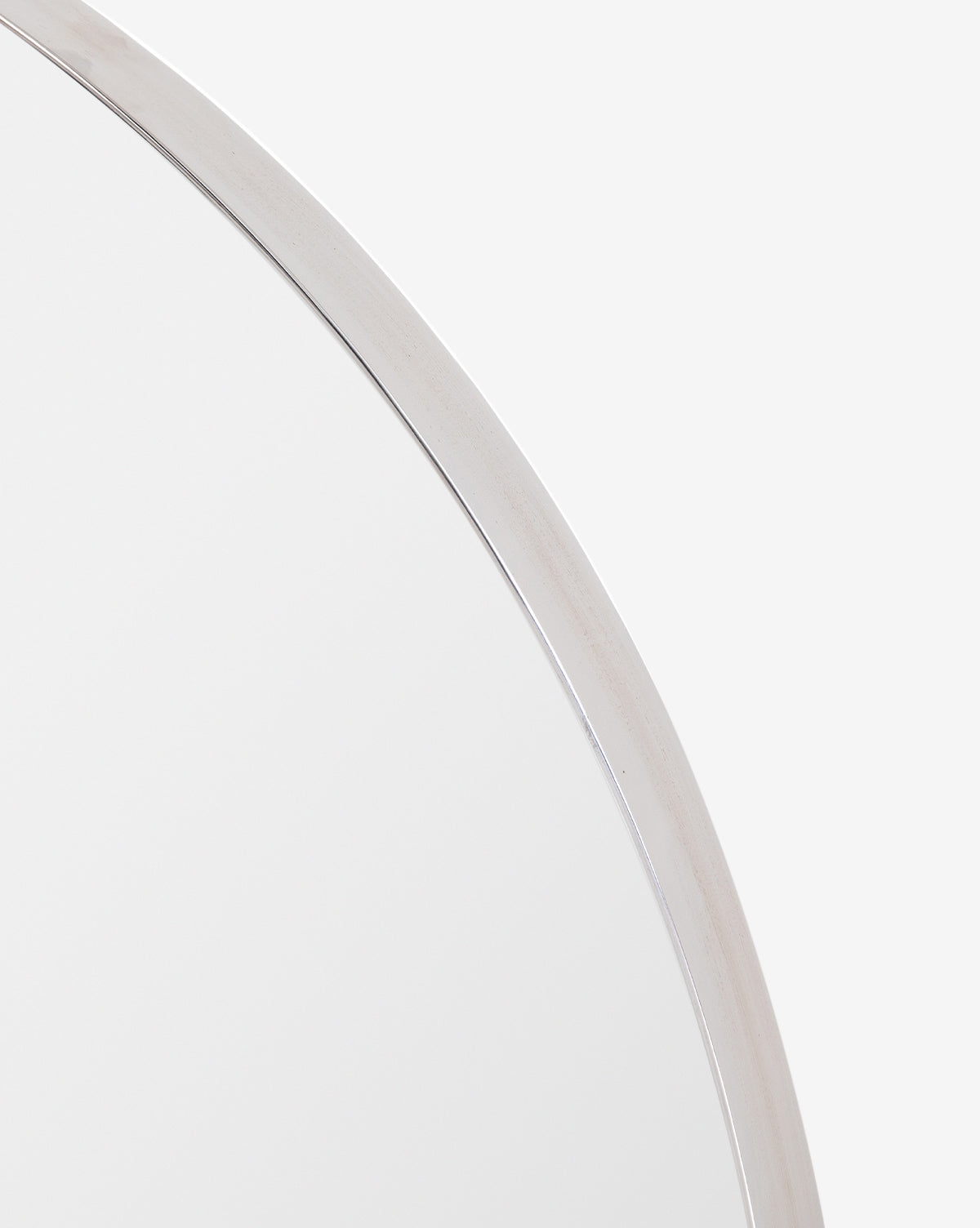 Close-up of the top right section of the Solange Mirror, showcasing its minimalist design with a thin stainless steel frame against a plain white background, by McGee & Co.