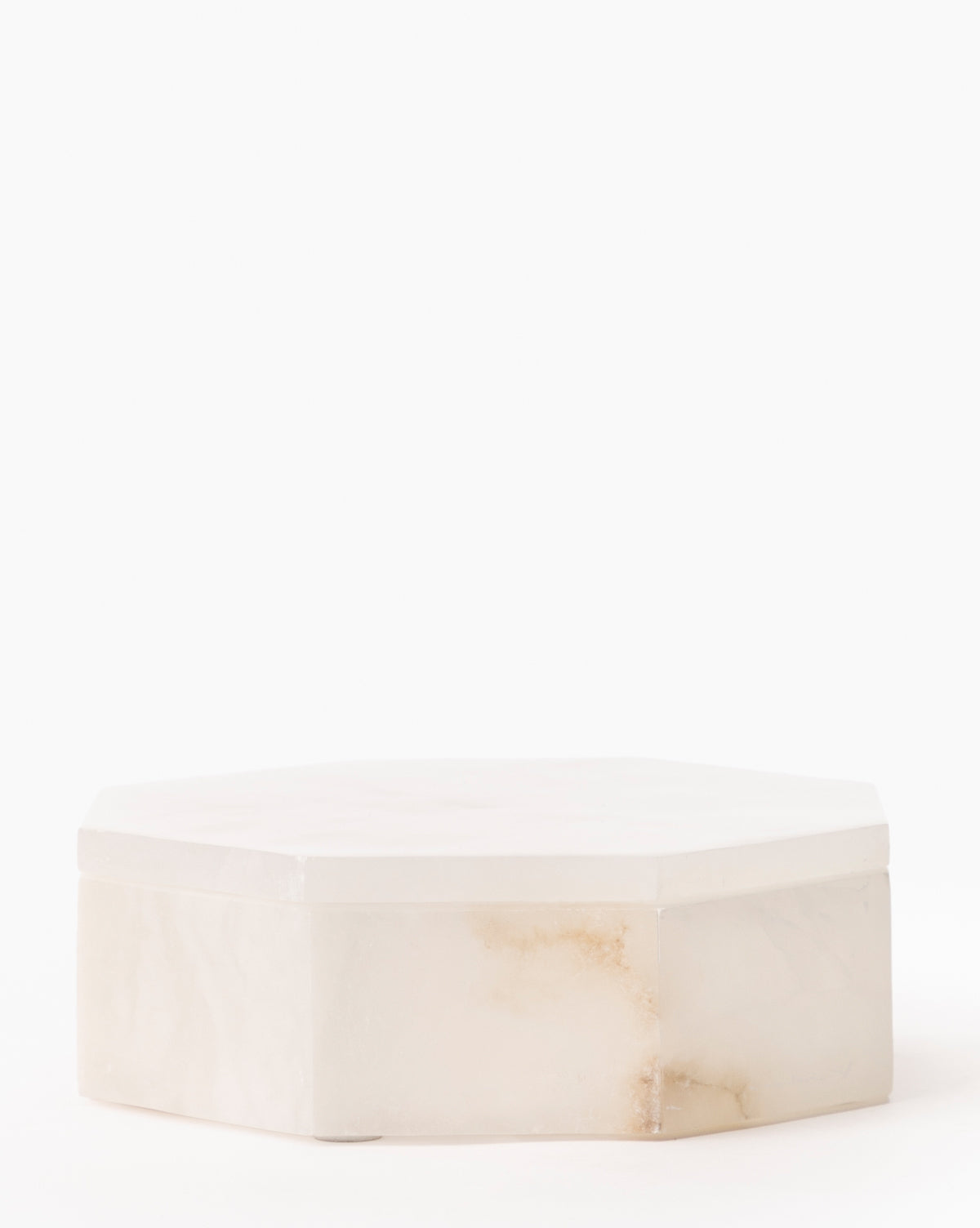 The Sonya Alabaster Box features an elegant hexagonal design in white marble with subtle brown veining, displayed on a plain white background.