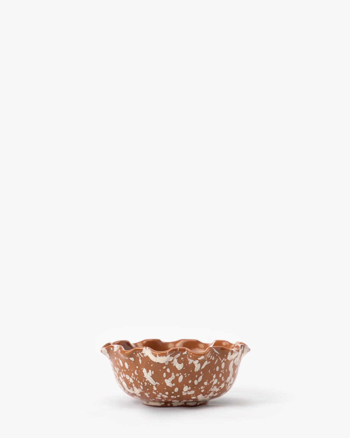 The Splatter Scallop Dish is a small, artisan ceramic bowl featuring a wavy rim and white speckled pattern, displayed on a plain white background by McGee & Co.