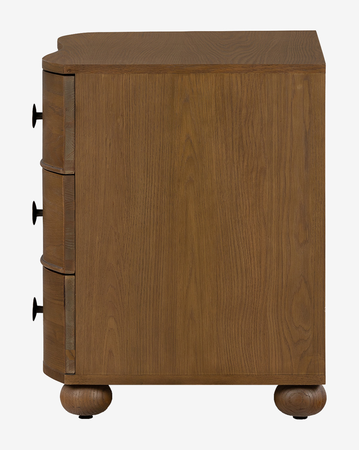 Side view of the Strasburg Nightstand—a wooden dresser with three drawers, black round knobs, rounded front edges, two round ball-shaped feet, and a natural medium-brown finish—ideal for bedroom styling as an antique nightstand, by McGee & Co.