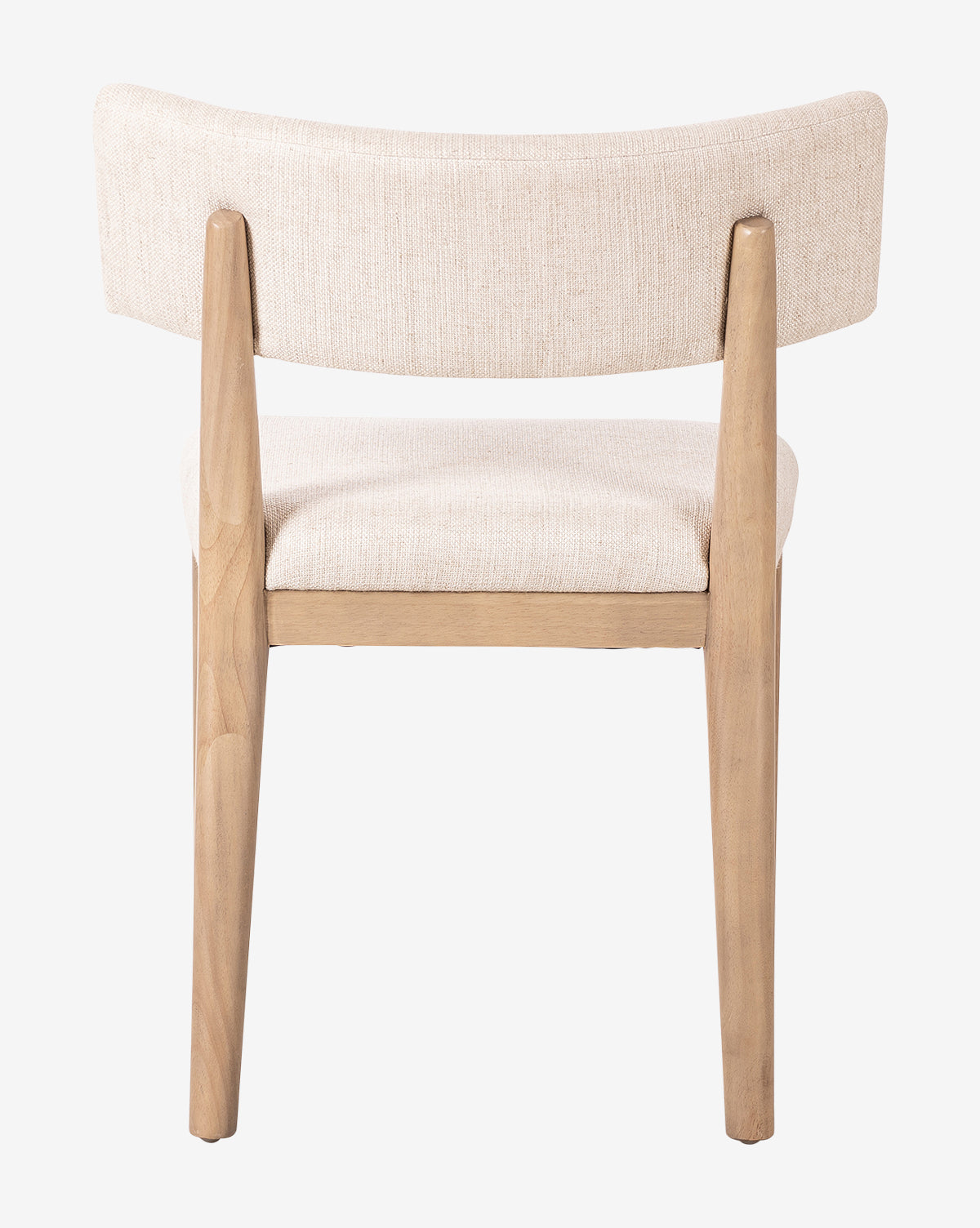 The Swift Dining Chair is shown from the back against a plain white background, featuring light wood legs and frame with a curved, upholstered beige fabric backrest and seat, by McGee & Co.