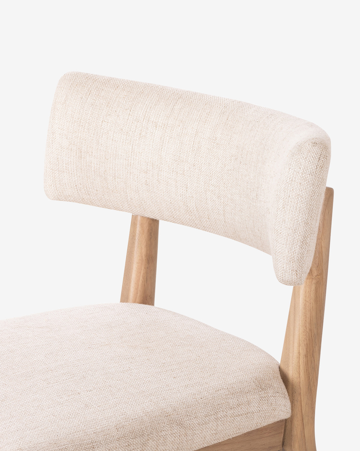 A close-up of the Swift Dining Chair featuring a light wood frame, upholstered beige fabric seat, and curved backrest, displayed against a plain white background, by McGee & Co.