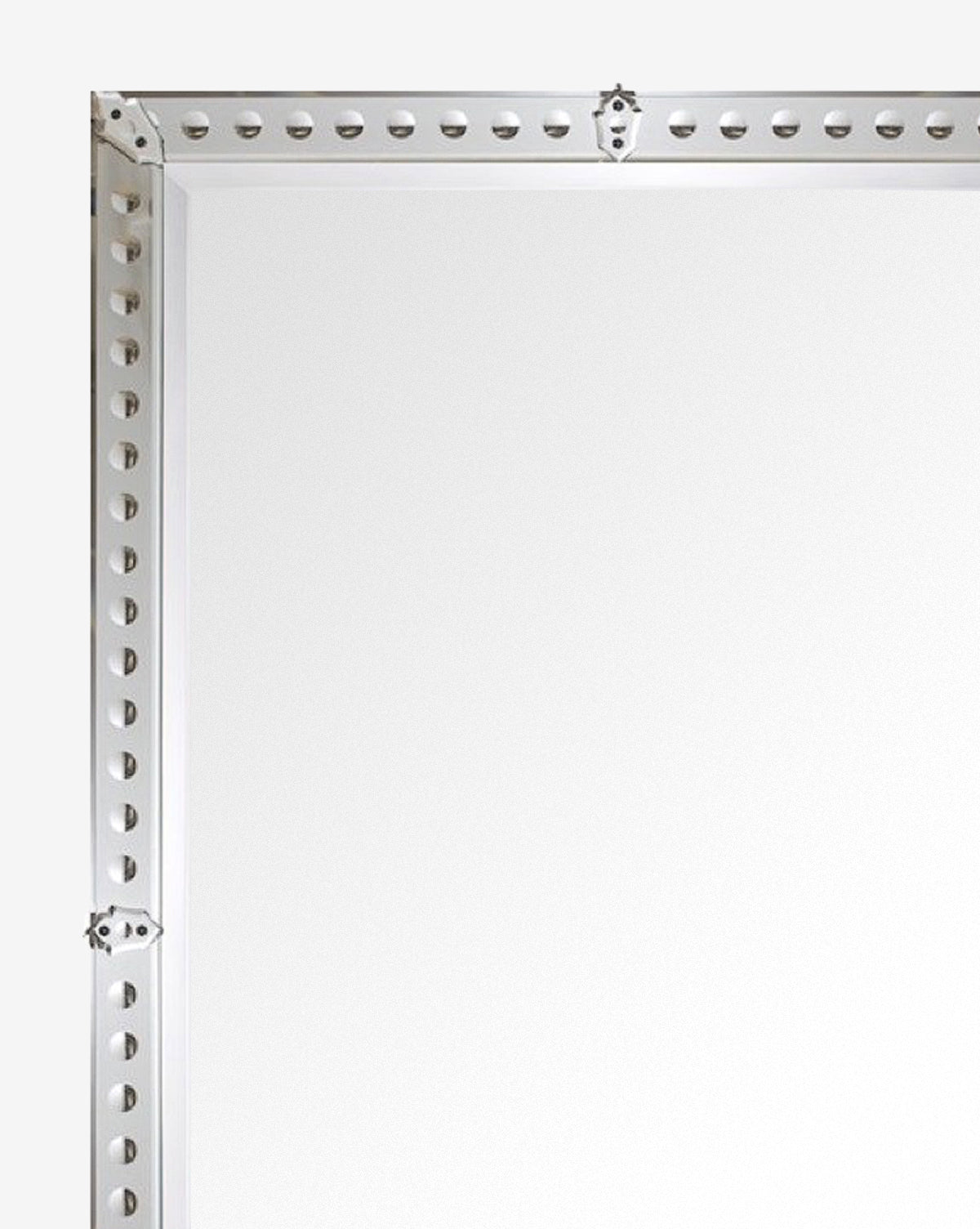 Close-up of the top left corner of the Truman Mirror’s metal frame against a white background, showing evenly spaced holes along the edges for mounting or assembly, by McGee & Co.