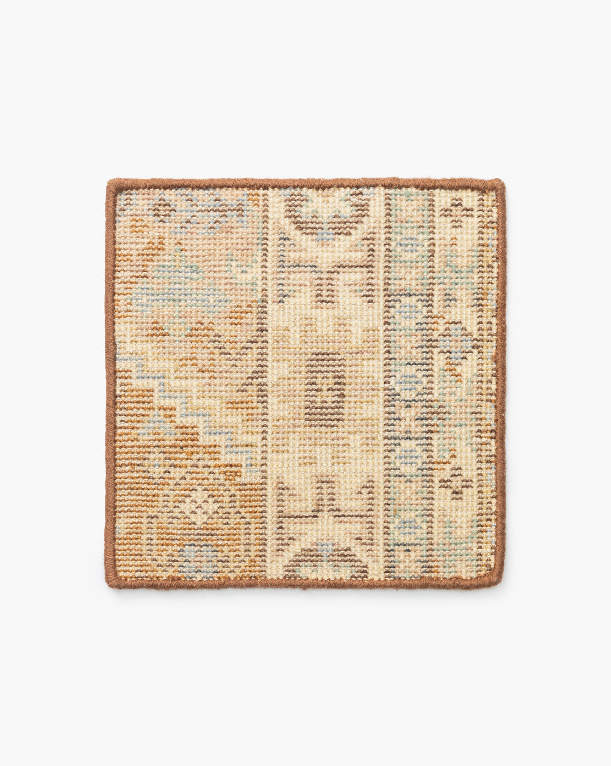The Tulie Hand-Knotted Wool Rug Swatch is a square sample featuring a patchwork of geometric and abstract patterns in muted beige, brown, blue, and green tones, accented with a solid brown border by McGee & Co.