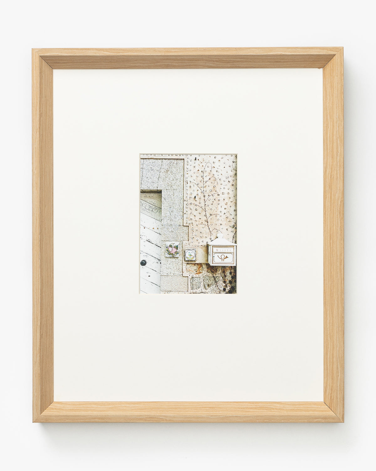 The Valldemossa is a giclee print of minimalist, textured shapes in neutral tones centered on a white mat, beautifully presented in a natural woodgrain frame.