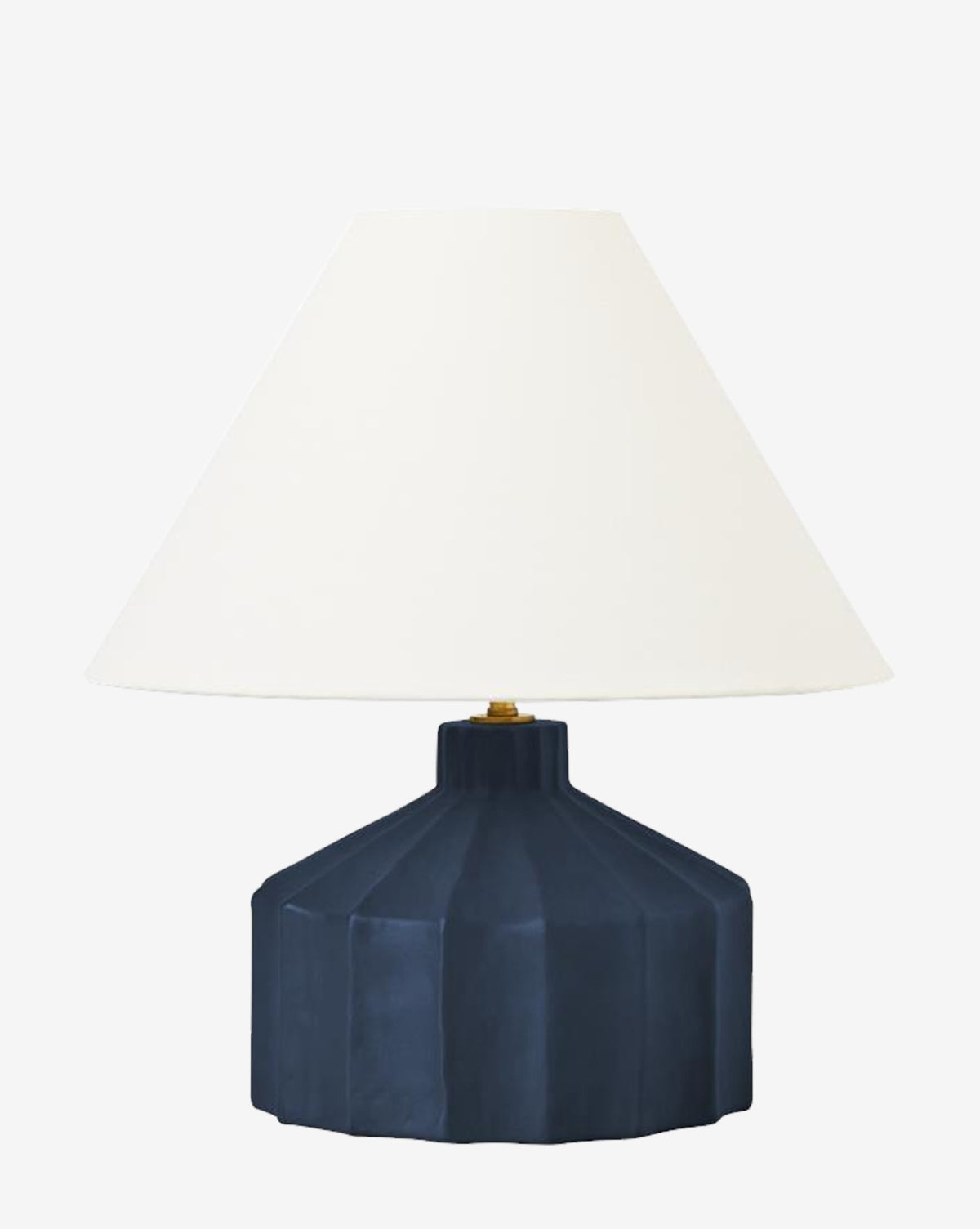 The Veneto Table Lamp showcases a wide, faceted dark blue ceramic base paired with a large, conical white lampshade, blending fluted details with classic style against a plain white backdrop, by McGee & Co.