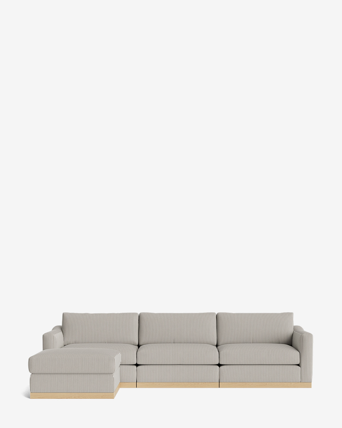 The Vernon Modular Sofa with Ottoman 121 in light gray features a left chaise, low wooden base, clean lines, and plush cushions. This customizable fabric sofa is shown against a plain white background by McGee & Co.