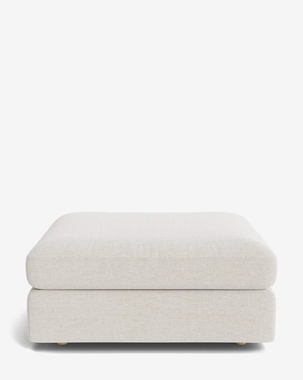 The Vivienne Modular Ottoman is a modern, rectangular piece with light beige fabric upholstery, a plush cushion top, and low wooden feet, shown against a plain white background by McGee & Co.