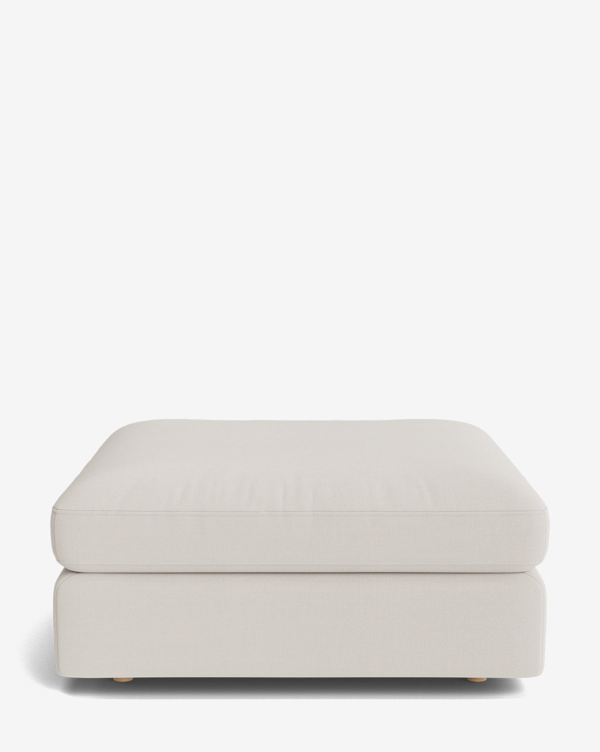 The Vivienne Modular Ottoman features a modern rectangular design in light beige, with a cushioned top and low wooden legs, displayed against a plain white background by McGee & Co.
