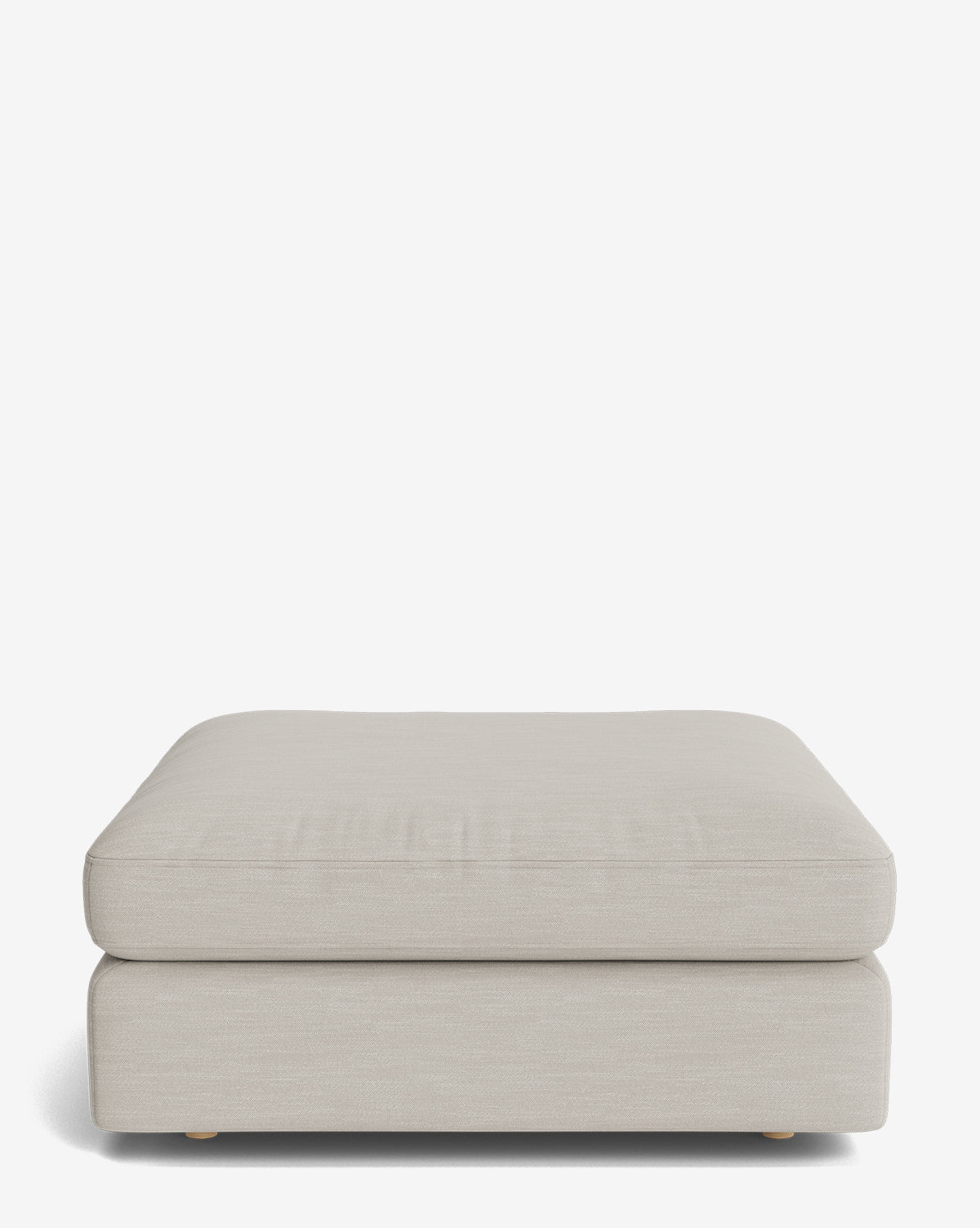The Vivienne Modular Ottoman is a square, light beige handmade piece with a cushioned top, low wooden feet, and a simple modern design, shown against a plain white background by McGee & Co.