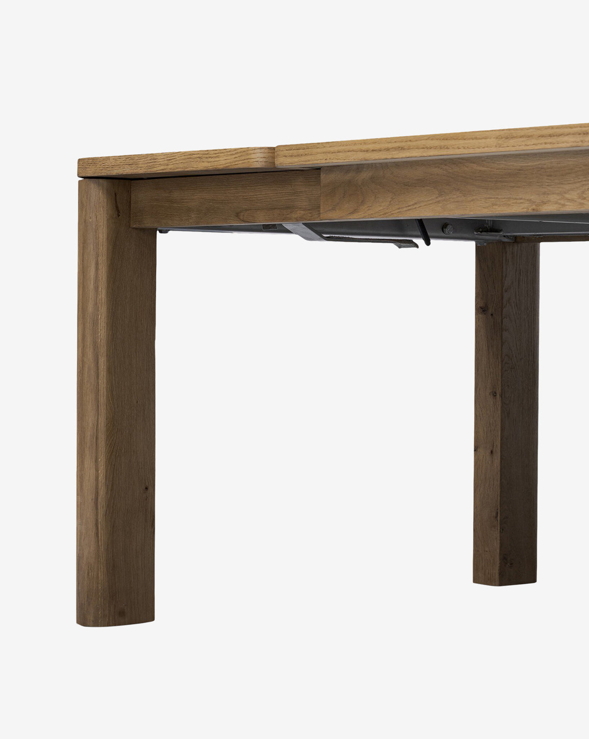 Close-up of the Wagner Extension Dining Table’s corner, highlighting its sturdy build with thick legs and natural wood finish, shown against a plain white background, by McGee & Co.