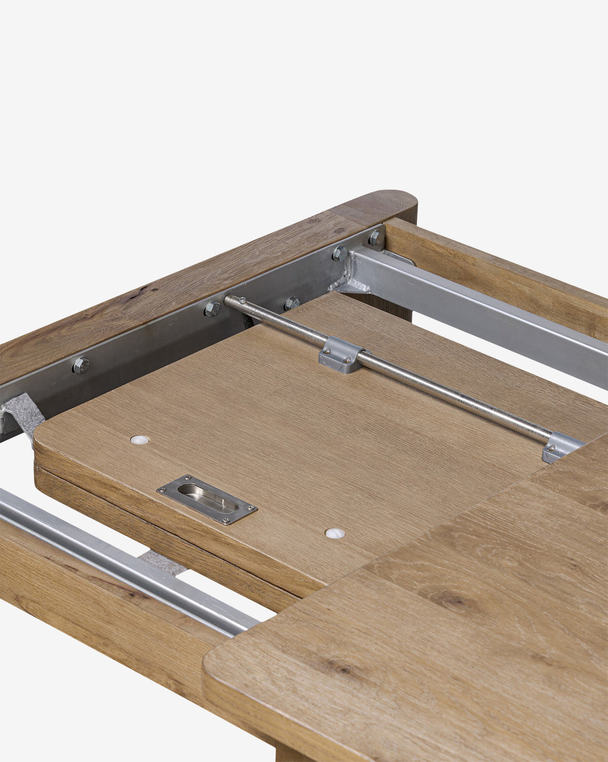 Close-up of the Wagner Extension Dining Table, highlighting its sturdy construction, extendable oak tabletop, and metal rails with the extension leaf partially extended, by McGee & Co.