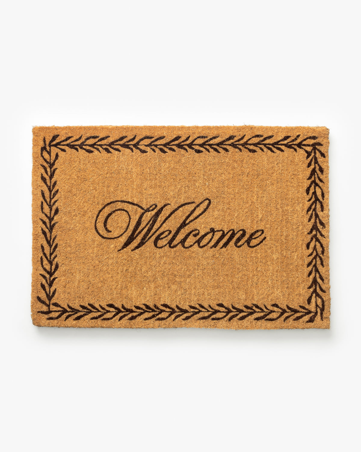 The Welcome Doormat with Leaf Border features a rectangular coir design with Welcome in elegant script at the center, framed by a decorative leaf border on a plain white background, by McGee & Co.