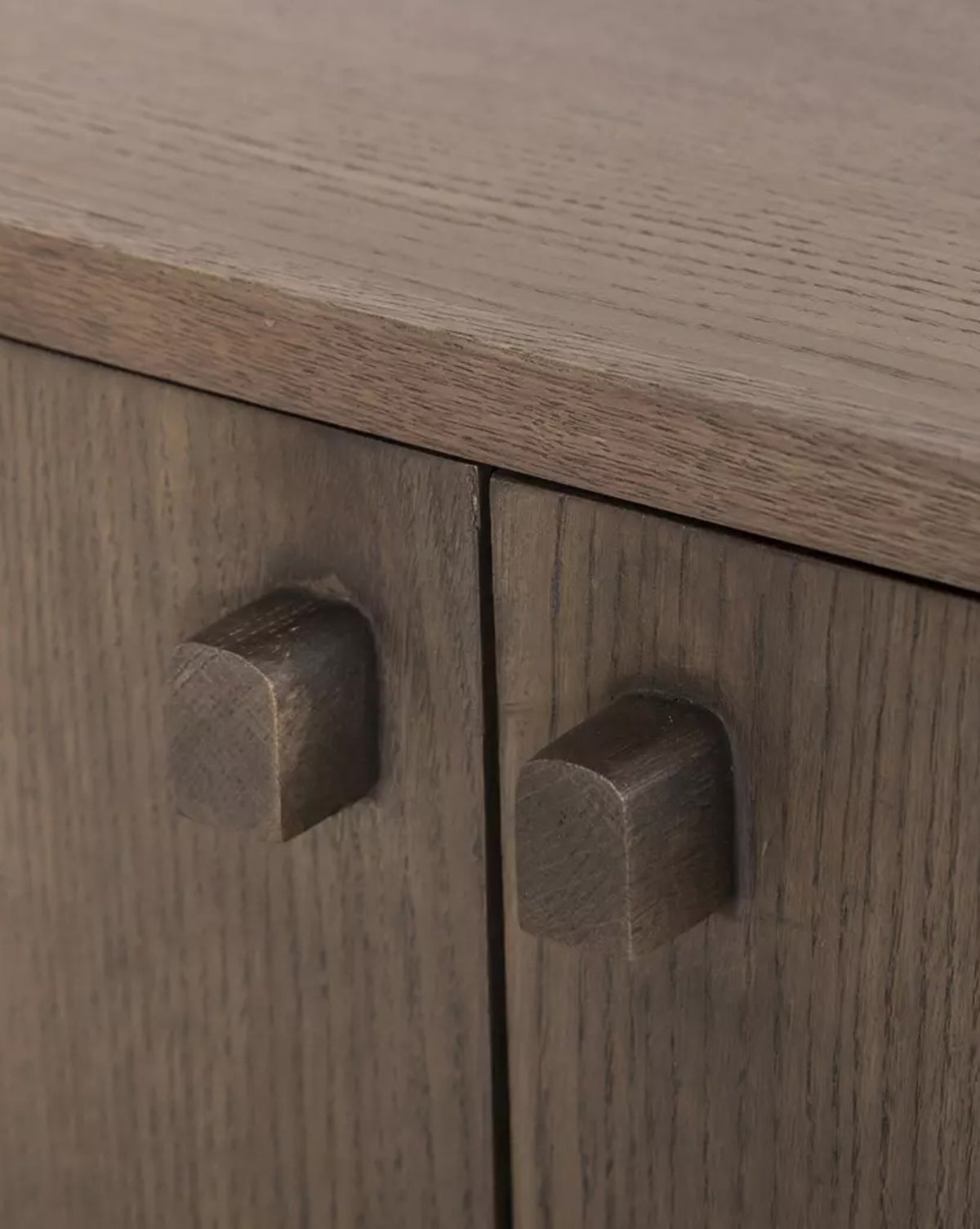 Close-up of two wooden cabinet doors with square knobs on the Werner Aged Oak Sideboard, showcasing its natural finish and distinctive wood grain, by McGee & Co.