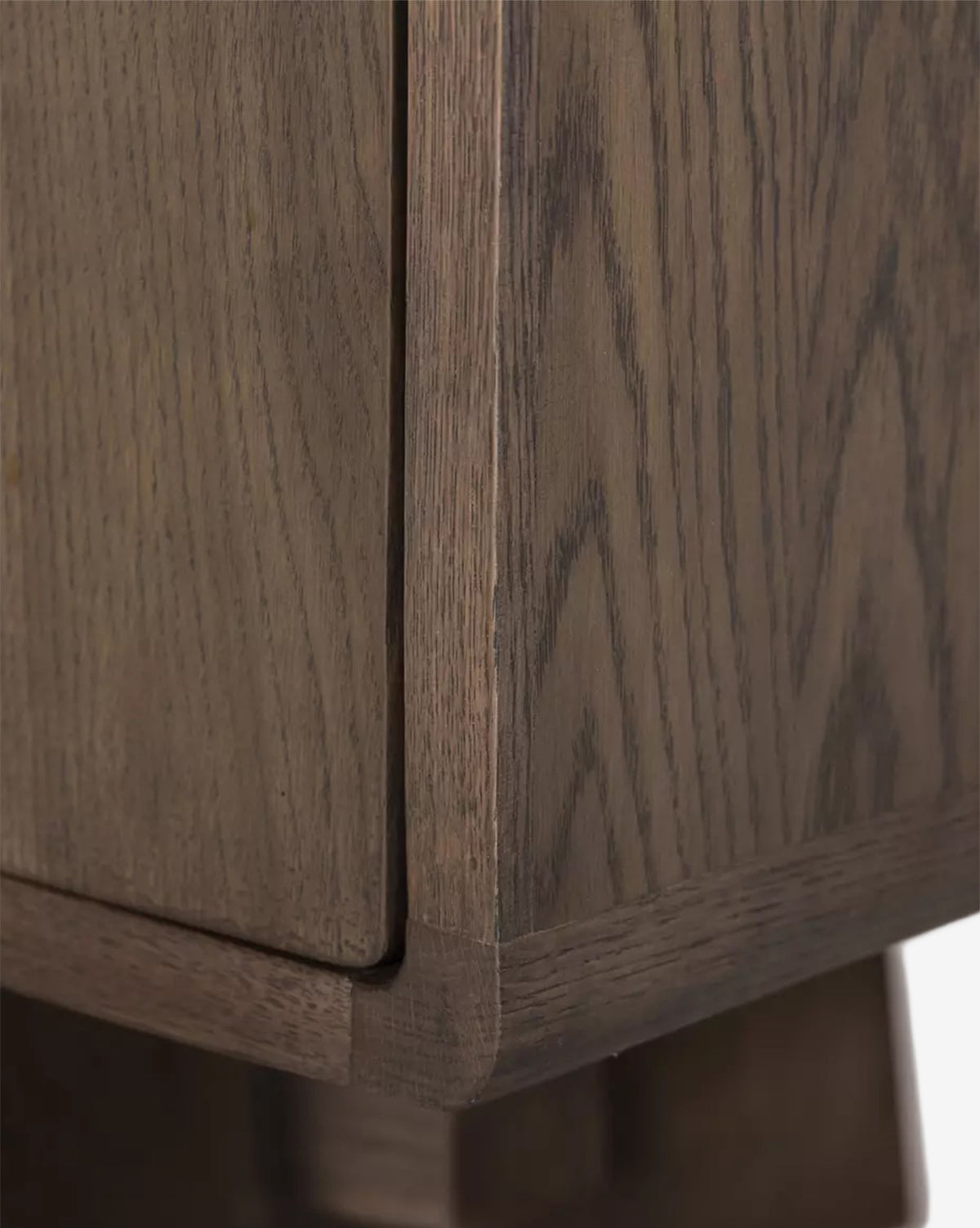 Close-up of the Werner Aged Oak Sideboard corner displays detailed wood grain, a natural brown finish, and clean modern lines, highlighting precise craftsmanship and the smooth texture of this contemporary sideboard by McGee & Co.