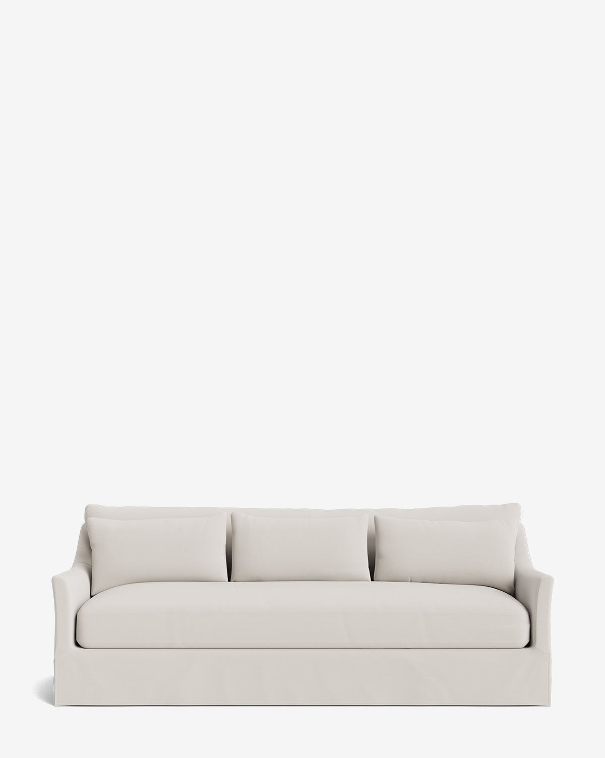 The Wilhelmina Classic Slipcover Sofa (85-110) is a modern, light beige sofa with three seat cushions, back pillows, curved armrests, and a fitted skirt, providing luxury seating against a plain white background by McGee & Co.