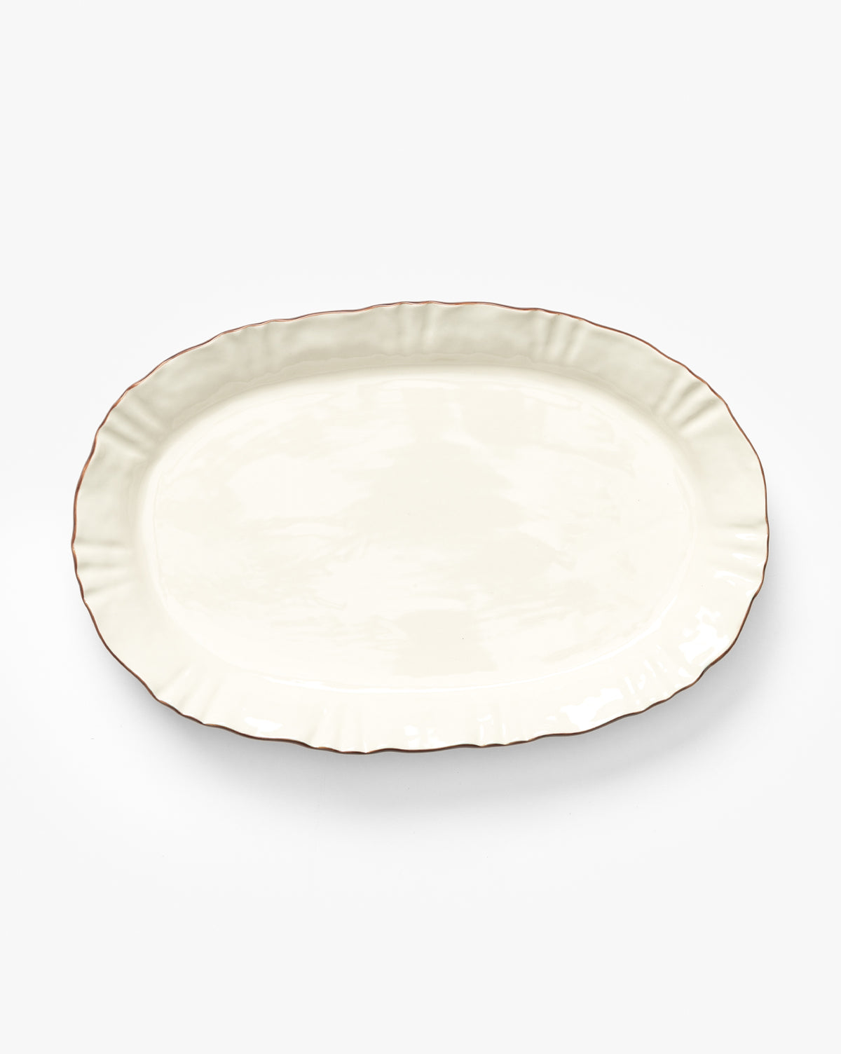 The Willow Serving Platter is an oval white ceramic plate featuring a slightly scalloped edge and a thin brown rim, inspired by heirloom design, by McGee & Co. It is shown on a plain white background.