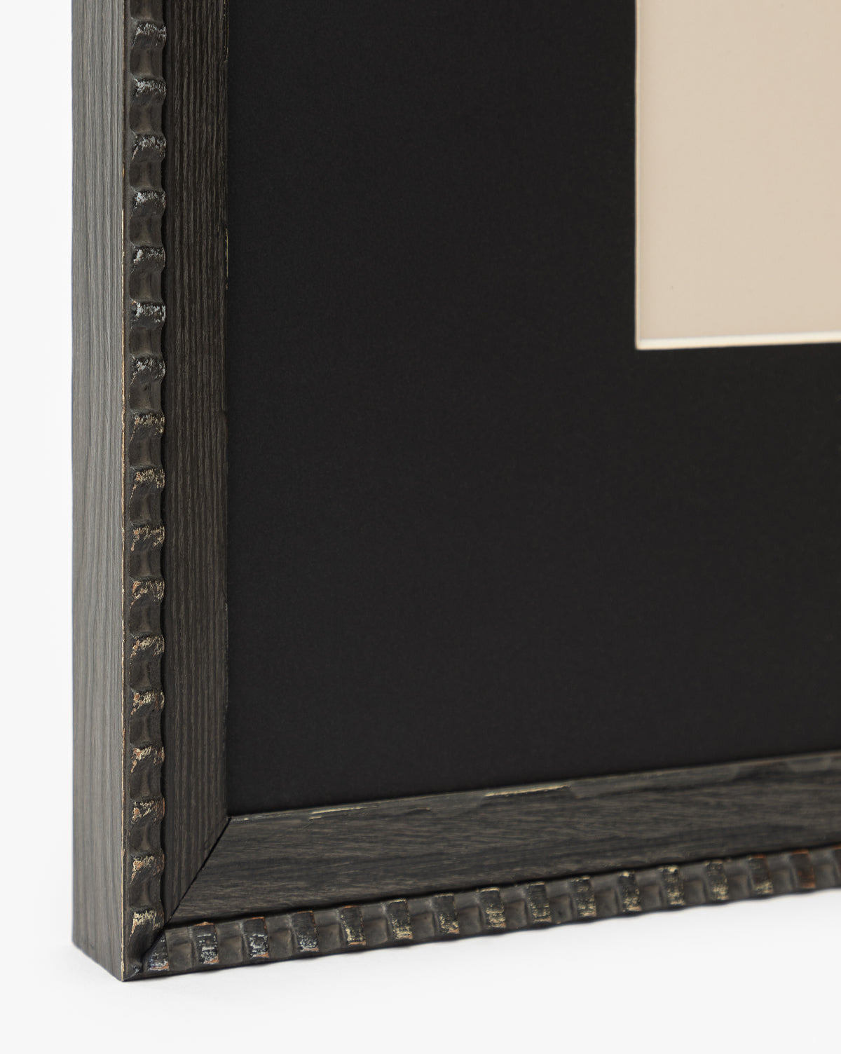 Close-up of Winnie, a black frame with a textured, ridged edge, matte finish, and black mat—partially displaying the corner of horse artwork. Ideal for making your wall art stand out, by McGee & Co.