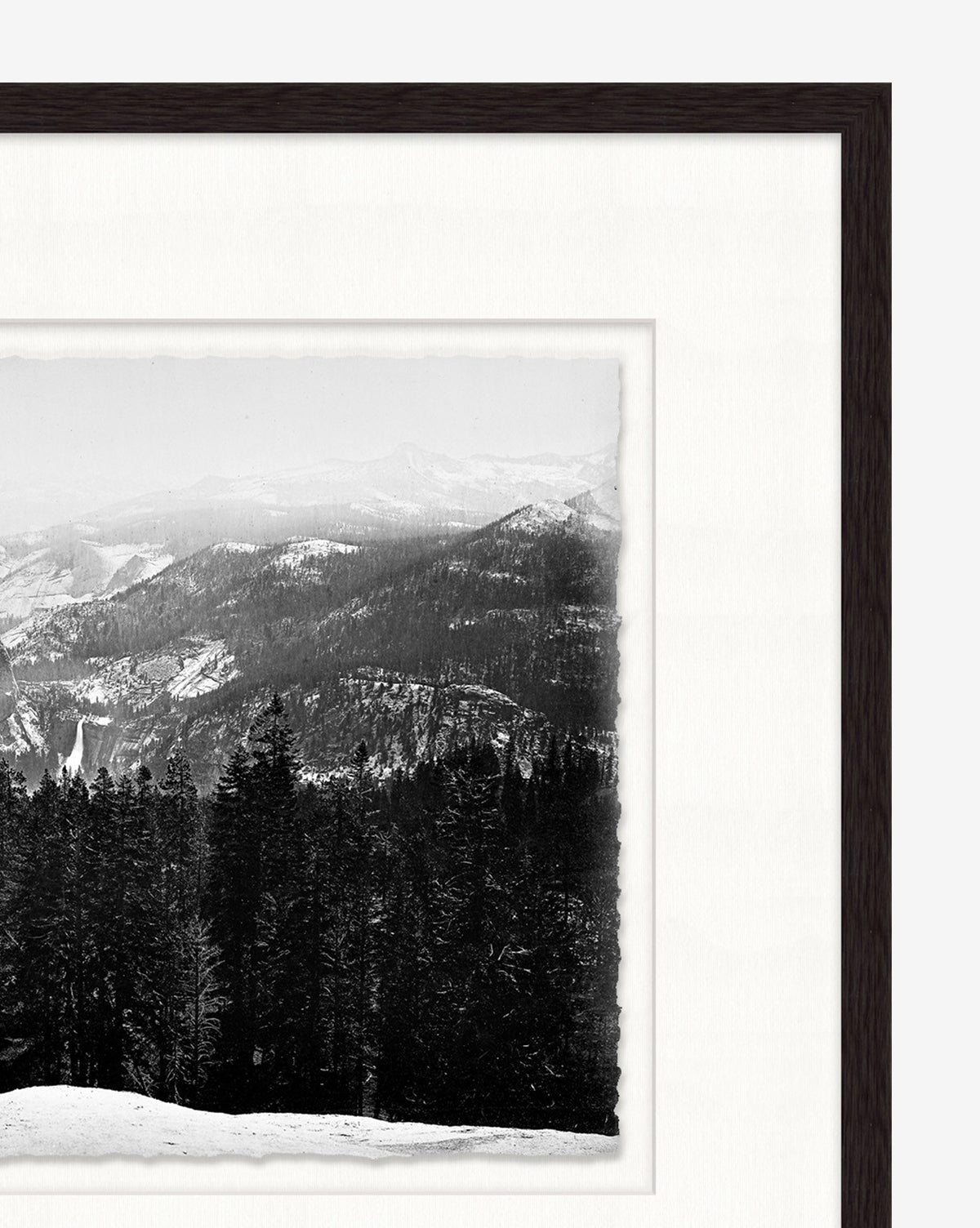 Winterscape is a black-and-white photo of snow-covered Rocky Mountain ridges and dense pines, framed with a white mat and dark wooden frame.