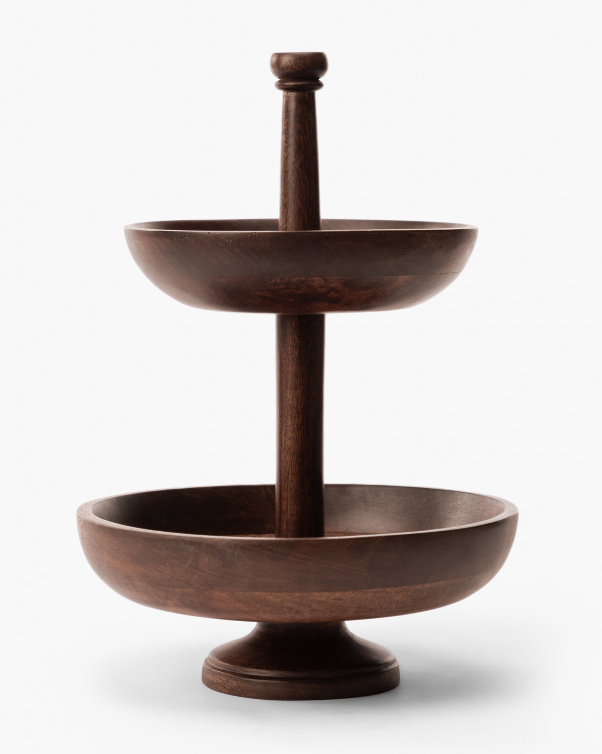 The Winward Tiered Pedestal is a two-tiered dark wood serving stand with round bowls on each level, sculpted design, central vertical support, and is displayed against a plain white background by McGee & Co.