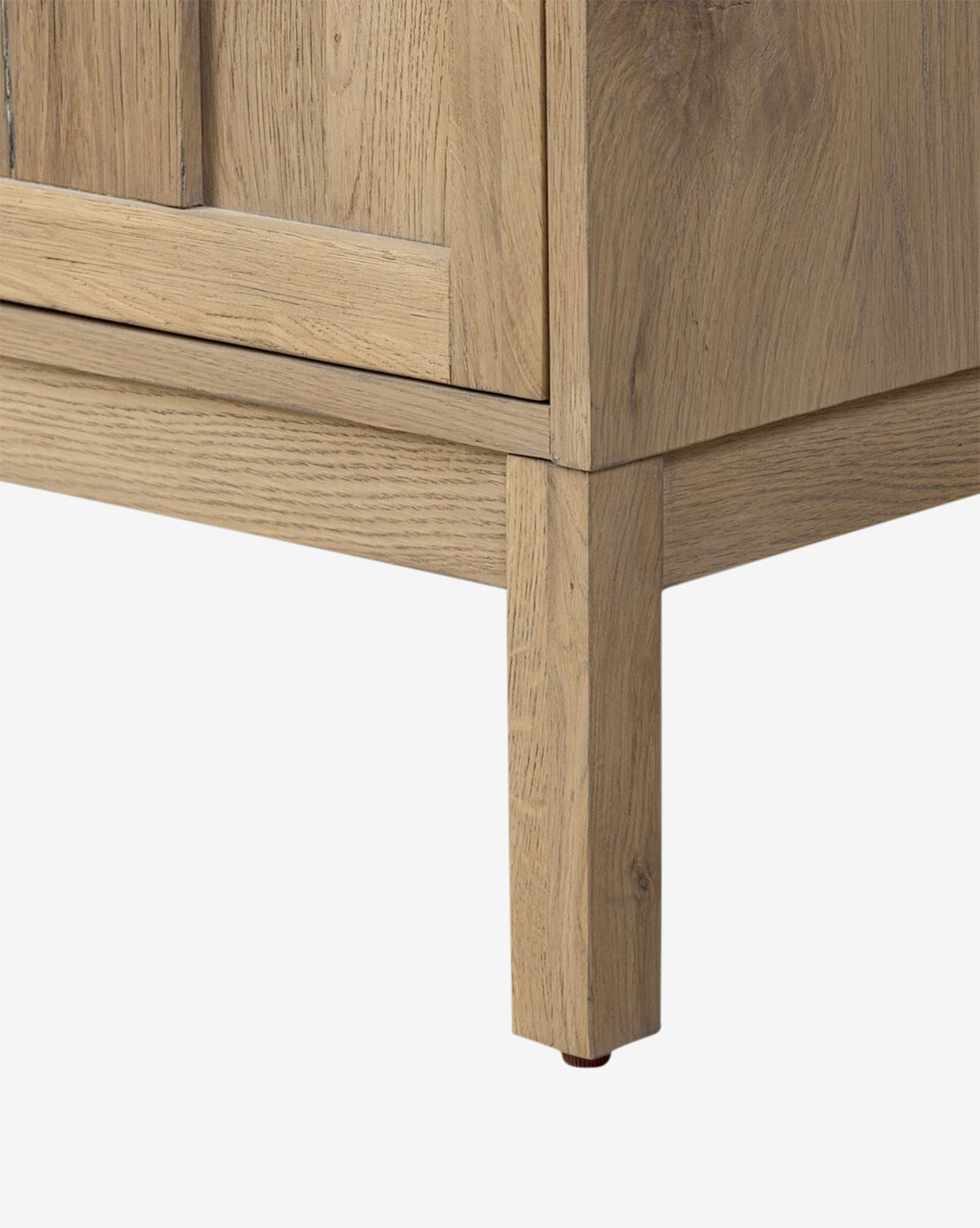 Close-up view of the bottom corner of the Wynne Sideboard, showcasing its solid oak leg and lower frame against a plain white background, by McGee & Co.