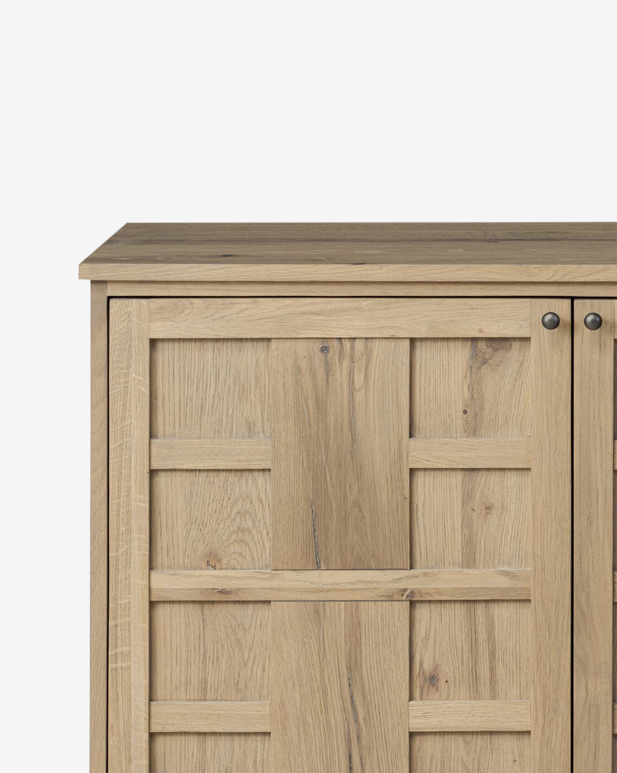 A close-up of the Wynne Sideboard, featuring a paneled door design in light oak with two round metal knobs—a stylish storage sideboard that adds warmth to any space, by McGee & Co.