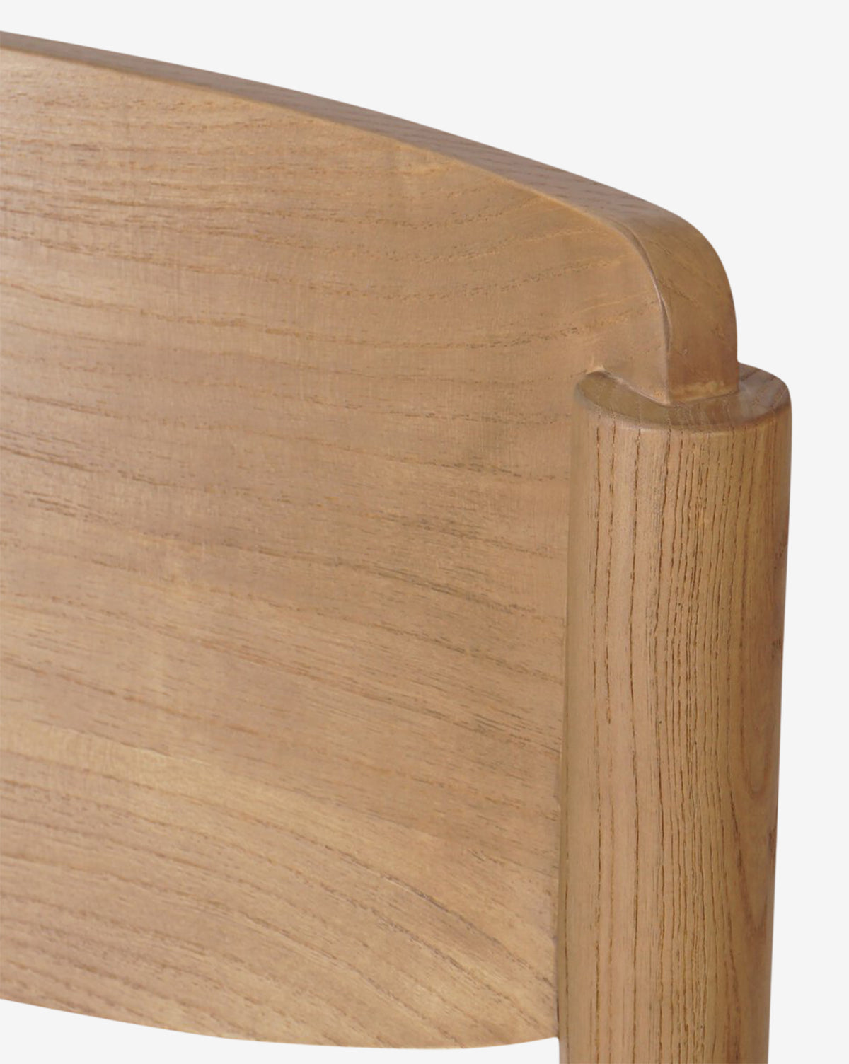 Close-up of the Reverie Dining Chair’s upper corner, highlighting its smooth, rounded wood frame edges, visible natural wood grain, and upholstered seat cushion by McGee & Co.